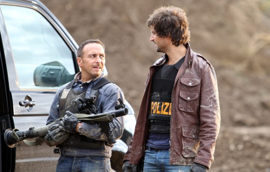 Tom Beck (als Autobahn-Polizist "Ben") und Erdogan Atatlay (li., als Autobahn-Polizist "Semir", mit Kunst-Blut am Mund und Panzerfaust) (beide mit kugelsicheren Westen), RTL-Krimi-Serie "Alarm für Cobra 11", Folge 236. "Hundstage" (19. Staffel), Kieswerk, Pulheim bei Köln, Nordrhein-Westfalen, Deutschland, Europa, Waffe, Schauspieler, Promi, 100225, NB, FTP; P.-Nr. 1421/2011, 18.09.2011; Foto: P.Bischoff; Jegliche Foto-Nutzung (Veröffentlichung - Print + Online - , Ausstrahlung, Layout etc.) nur gegen Honorar (lt. MFM-Empfehlungen) gemäß unseren AGB's !; (Photo by Peter Bischoff/Getty Images)