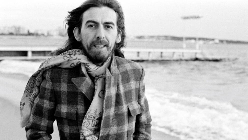 Former Beatle George Harrison (1943 - 2001) on the beach at Cannes, France in 1976. (Photo by Michael Putland/Getty Images)