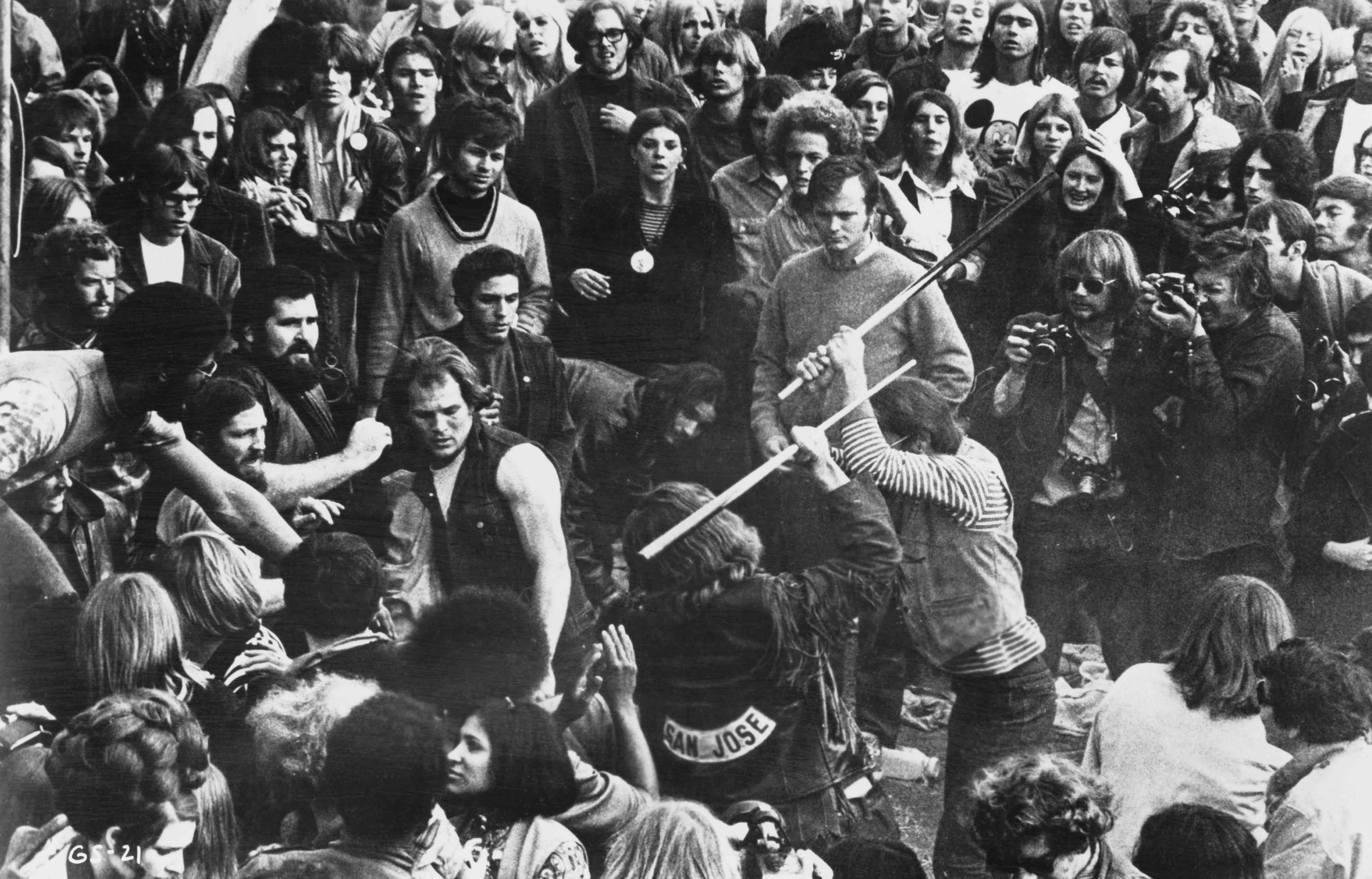 A still from the documentary film 'Gimme Shelter', showing audience members looking on as Hells Angels beat a fan with poo...