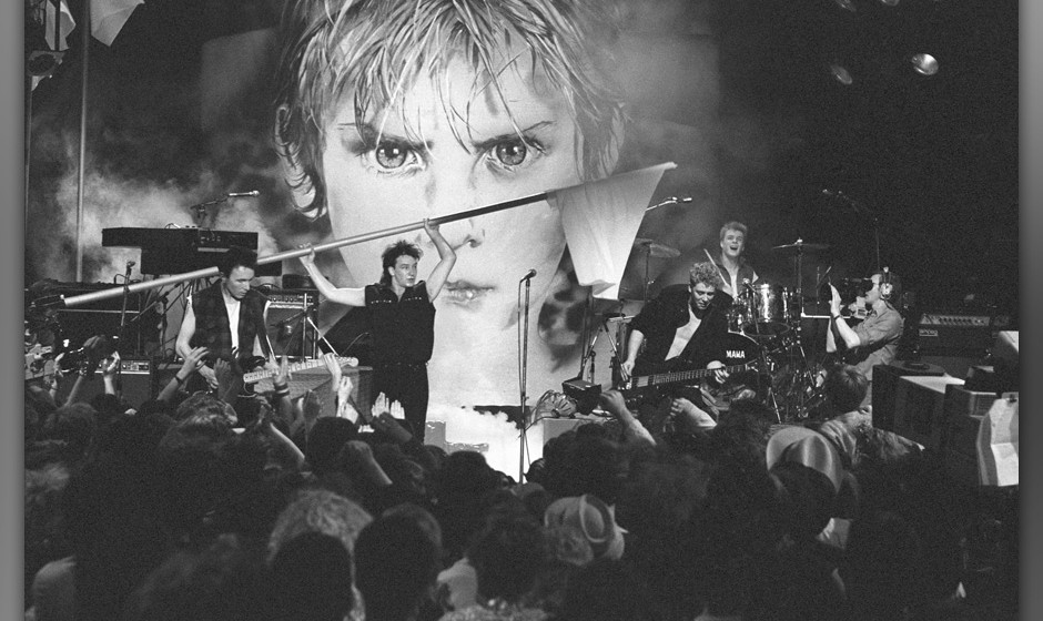 UNITED KINGDOM - MARCH 16:  Photo of U2; L-R: The Edge, Bono (waving flag), Adam Clayton, Larry Mullen Jnr performing live on