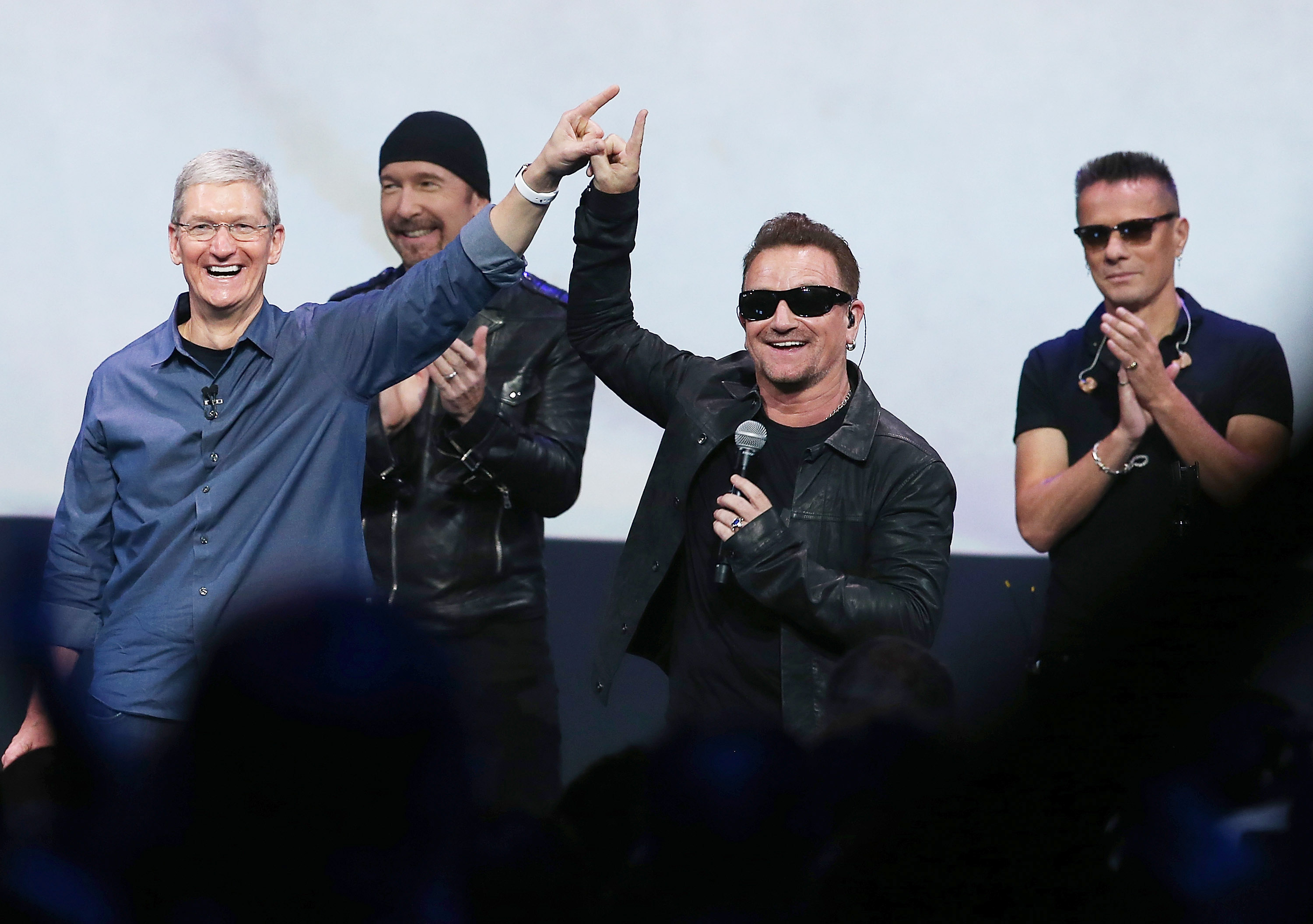 CUPERTINO, CA - SEPTEMBER 09:  Apple CEO Tim Cook (L) greets the crowd with U2 singer Bono (2nd R) as The Edge (2nd L) and...