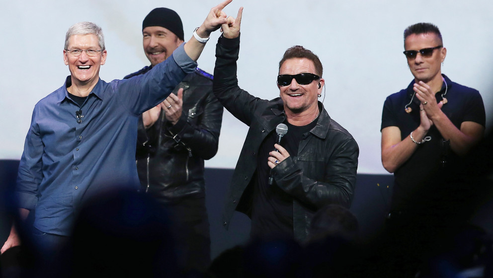 CUPERTINO, CA - SEPTEMBER 09:  Apple CEO Tim Cook (L) greets the crowd with U2 singer Bono (2nd R) as The Edge (2nd L) and La