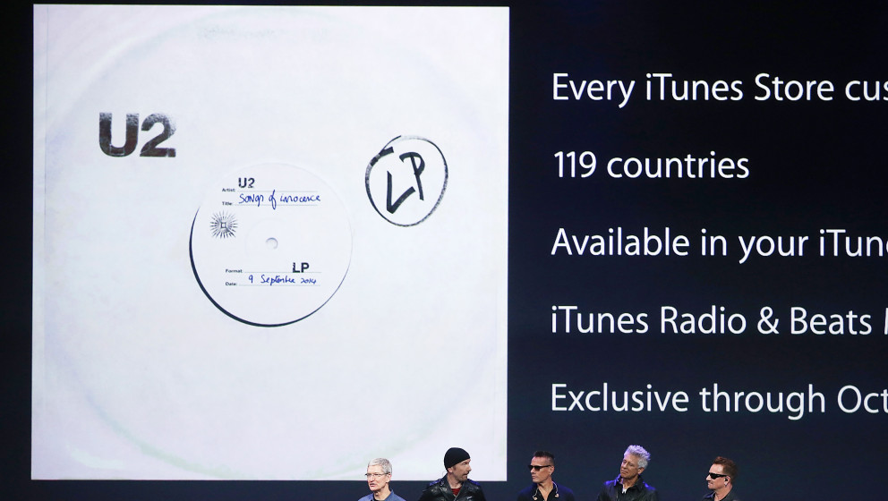CUPERTINO, CA - SEPTEMBER 09:  Apple CEO Tim Cook (L) announces the free download of the new U2 album on iTunes as members of