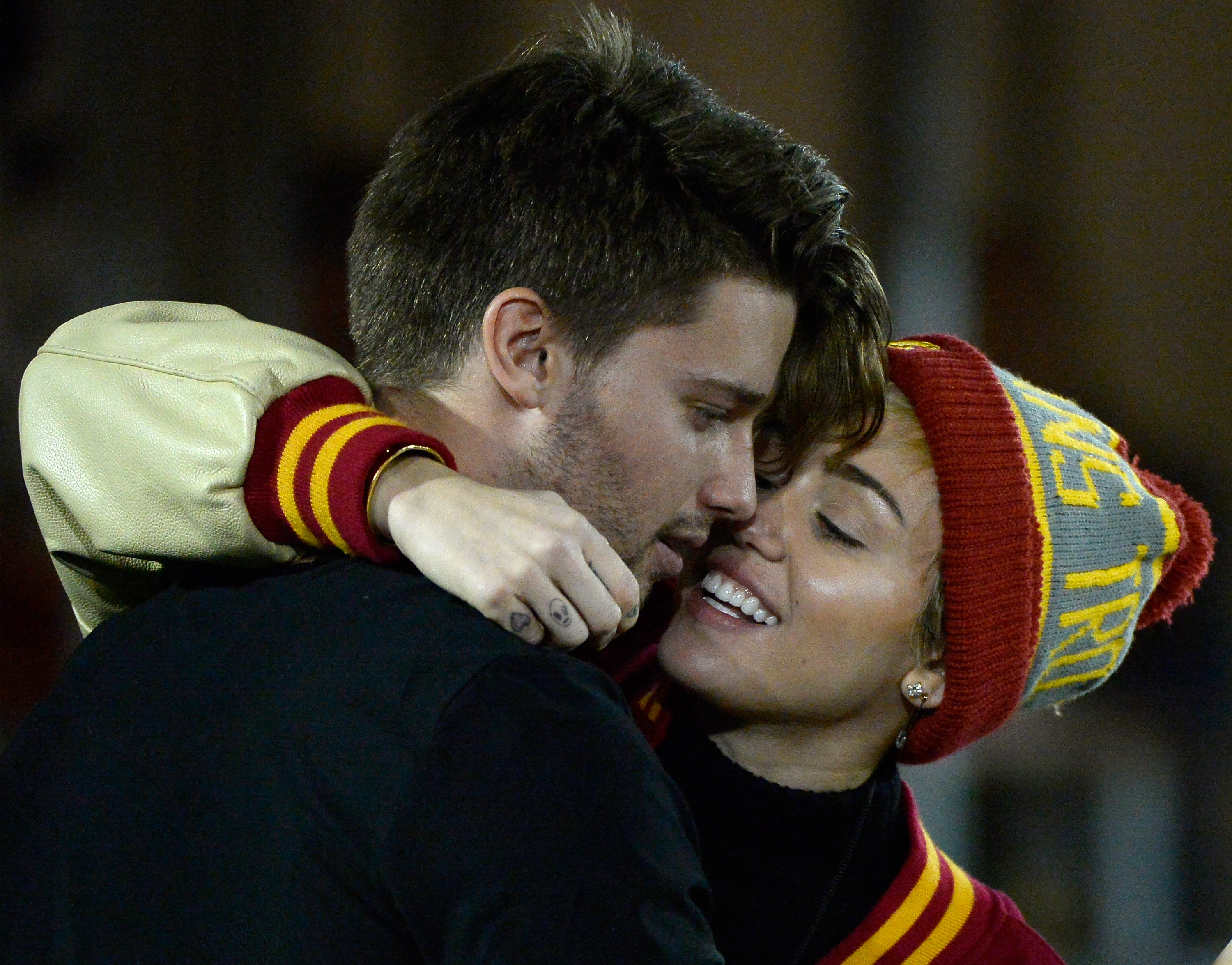 LOS ANGELES, CA - NOVEMBER 13:  Miley Cyrus (R) kisses Patrick Schwarzenegger during the game between the California Golde...
