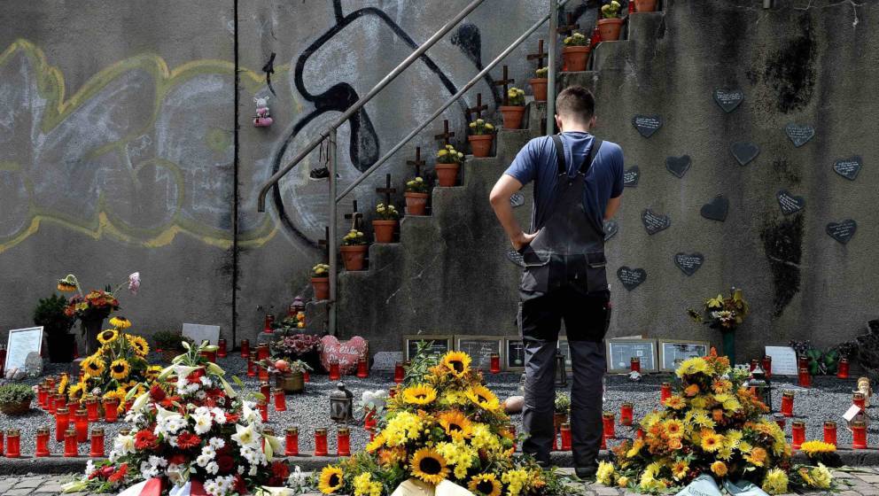 DUISBURG, GERMANY - JULY 24:  A man looks at candles and flowers left by mourners at the makeshift memorial to victims of the