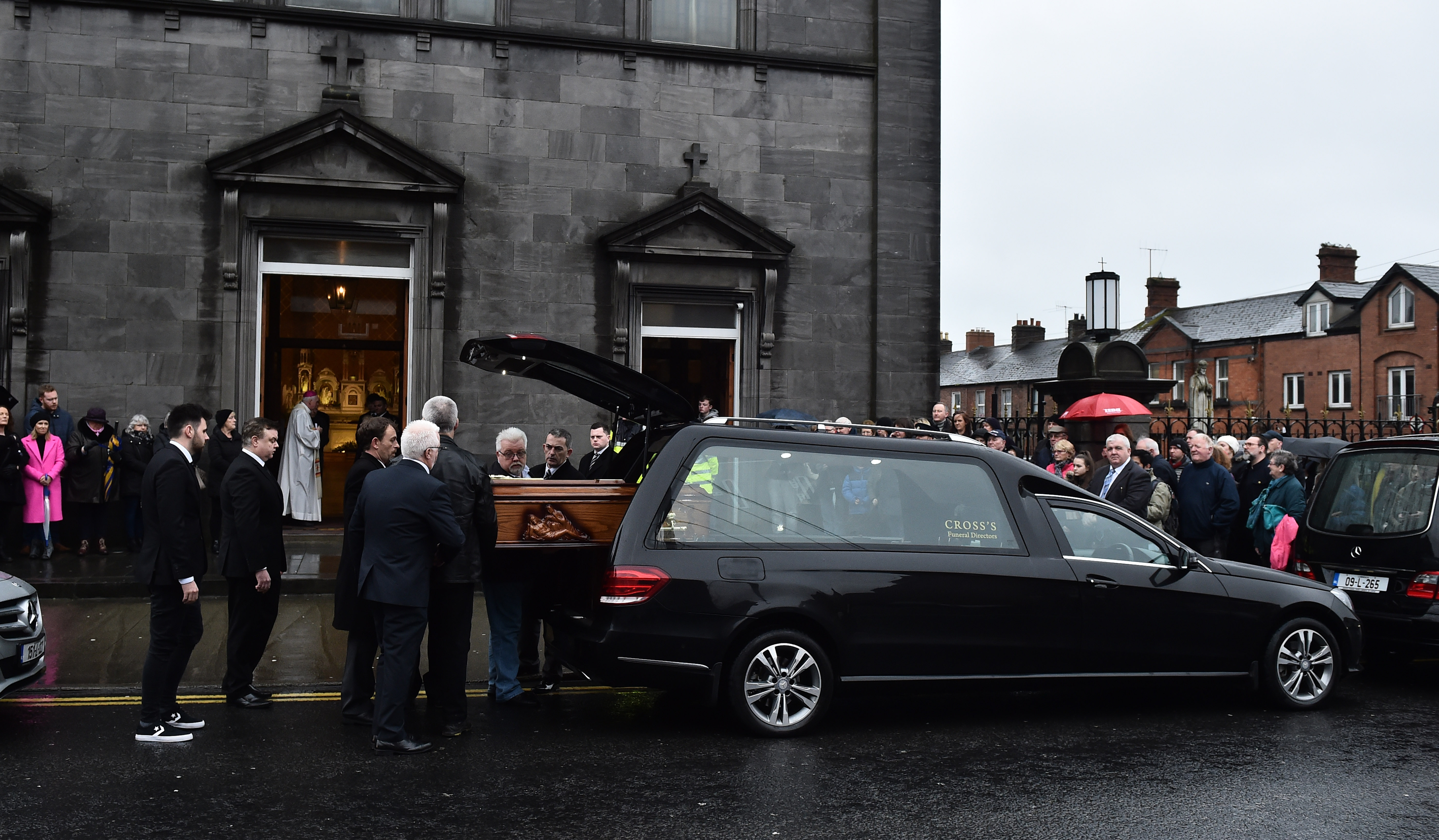 Die Angehörigen nehmen den Sarg in Empfang.