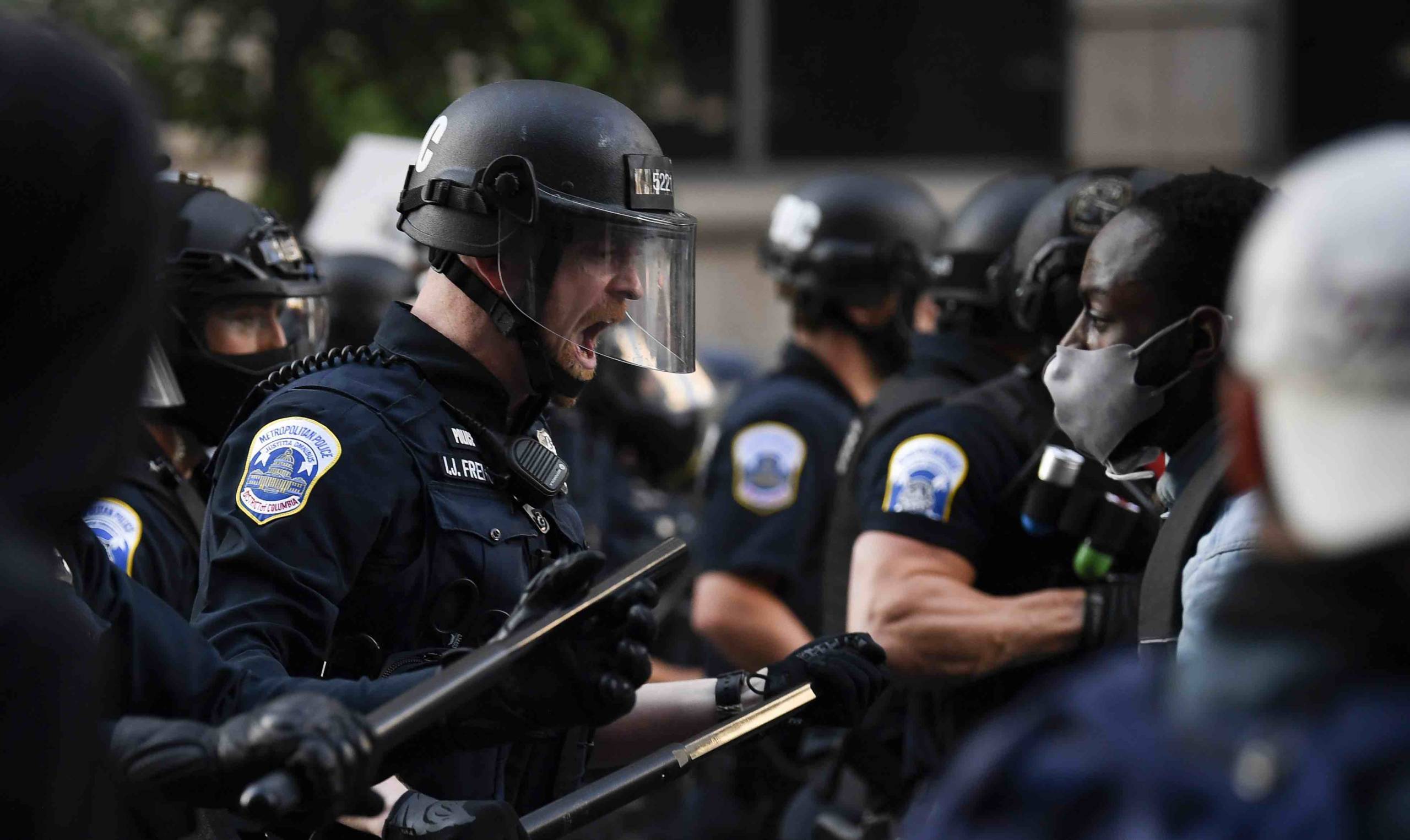 Ein Polizist in Kampfausrüstung reagiert mit deutlichen Worten auf Demonstranten, die sich in der Nähe des Weißen Hause...