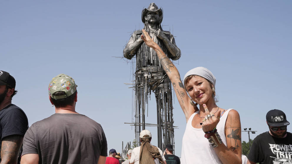 Künstlerin Caroline Brisset mit einem Gruß an die Metal-Szene vor ihrem Denkmal von Lemmy Kilmister