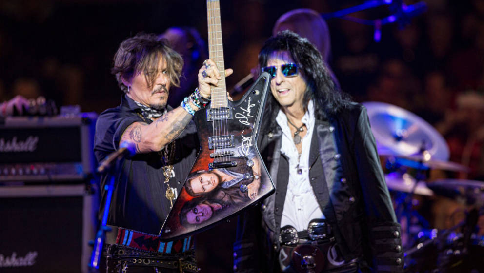 PHOENIX, ARIZONA - DECEMBER 14: Johnny Depp (L) and Alice Cooper auction a custom guitar on stage at Celebrity Theatre on Dec