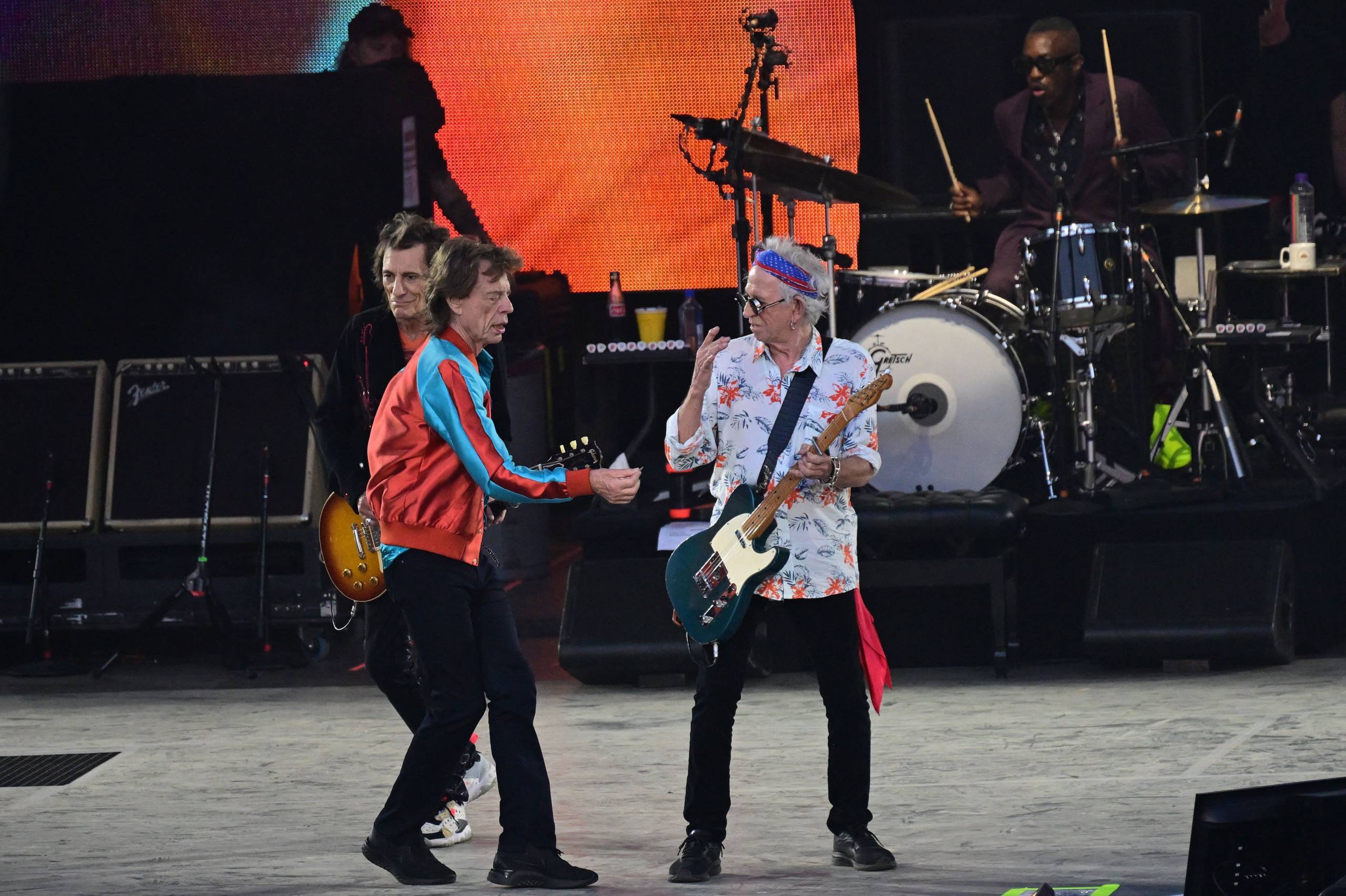 British rock band The Rolling Stones' singer Mick Jagger (front) hands guitarist Keith Richards (2nd R) his plectrum he dr...