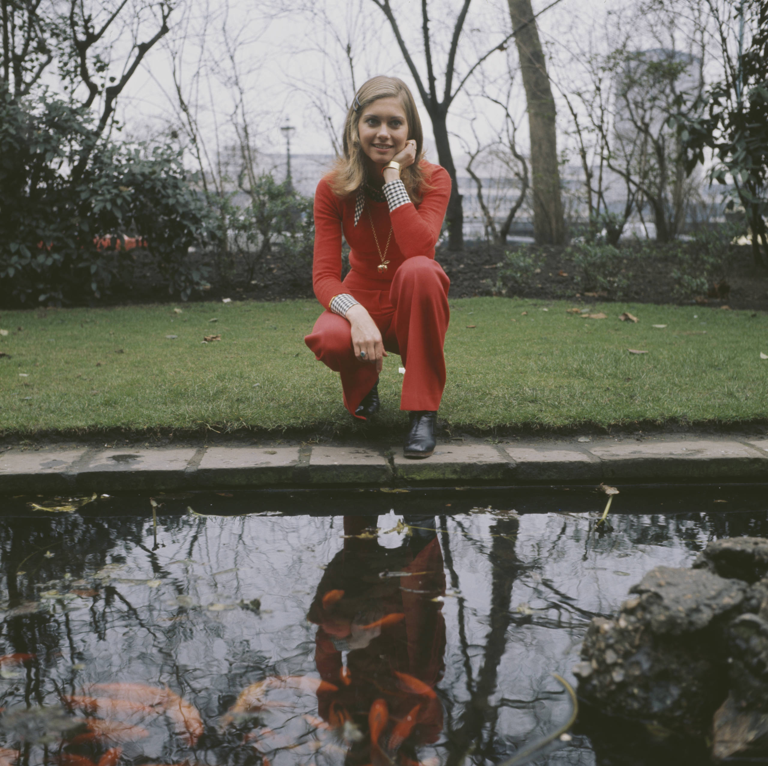 English-Australian singer, Olivia Newton-John, by a goldfish pond outside the Savoy Hotel in London, circa 1970. (Photo by...