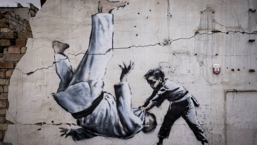 BORODYANKA, UKRAINE - NOVEMBER 11 Graffiti of a child throwing a man on the floor in judo clothing is seen on a wall amid dam