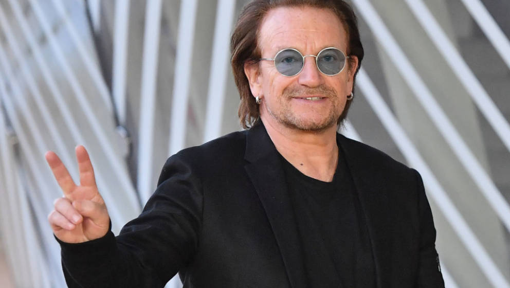 Irish rock band U2 singer Bono flashes the Victory sign upon his arrival at the European Council in Brussels on October 10, 2