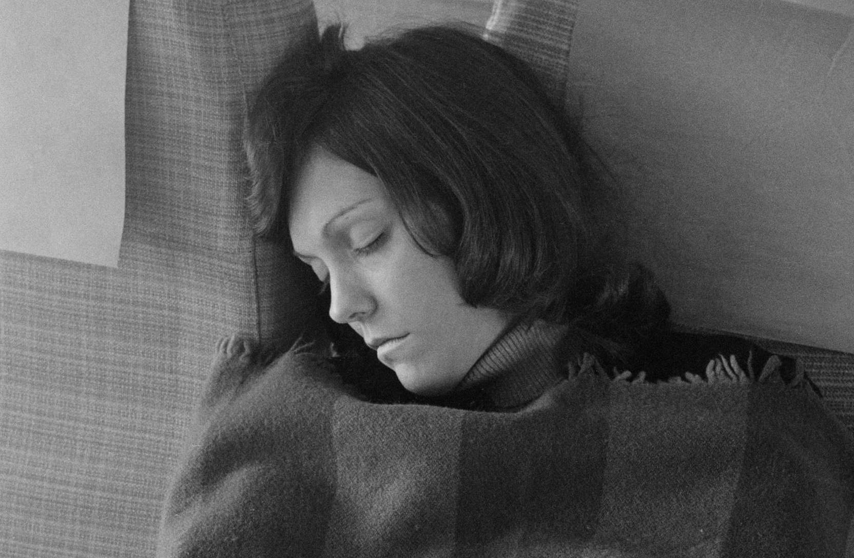 American singer and drummer Karen Carpenter (1950 - 1983), of pop duo The Carpenters, sleeping on an aircraft during a Eur...