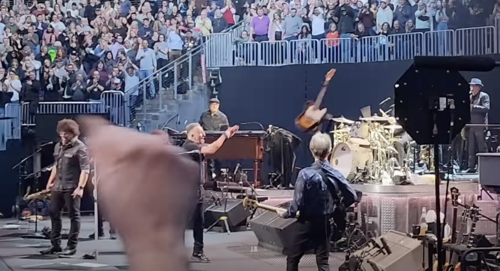 Nur Momente vor dem Unfall: Bruce Springsteen wirft seine Gitarre zu einem Techniker, doch der stolpert...