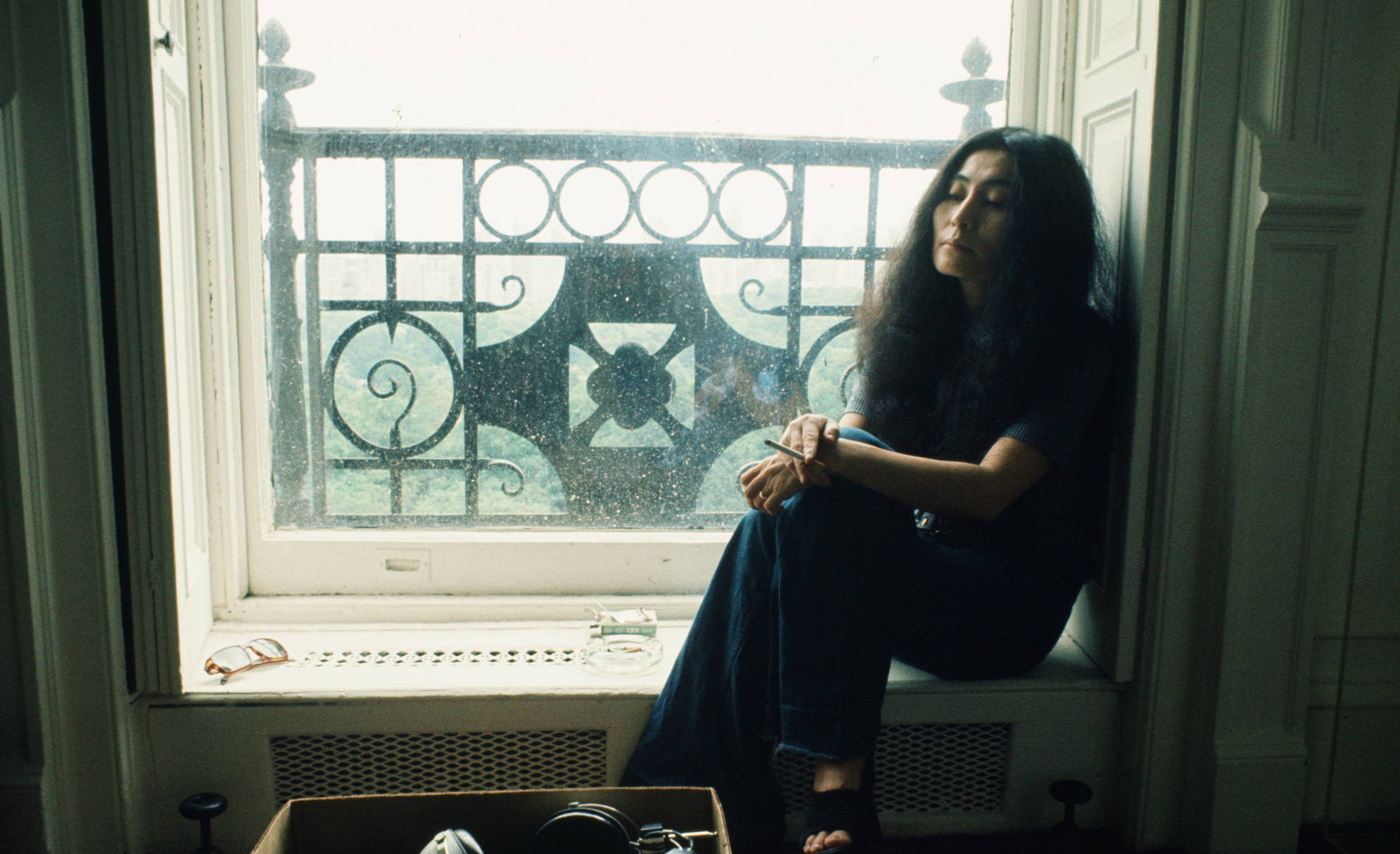 (MANDATORY CREDIT Koh Hasebe/Shinko Music/Getty Images) Yoko Ono sitting in the window of an apartment smoking, during an ...