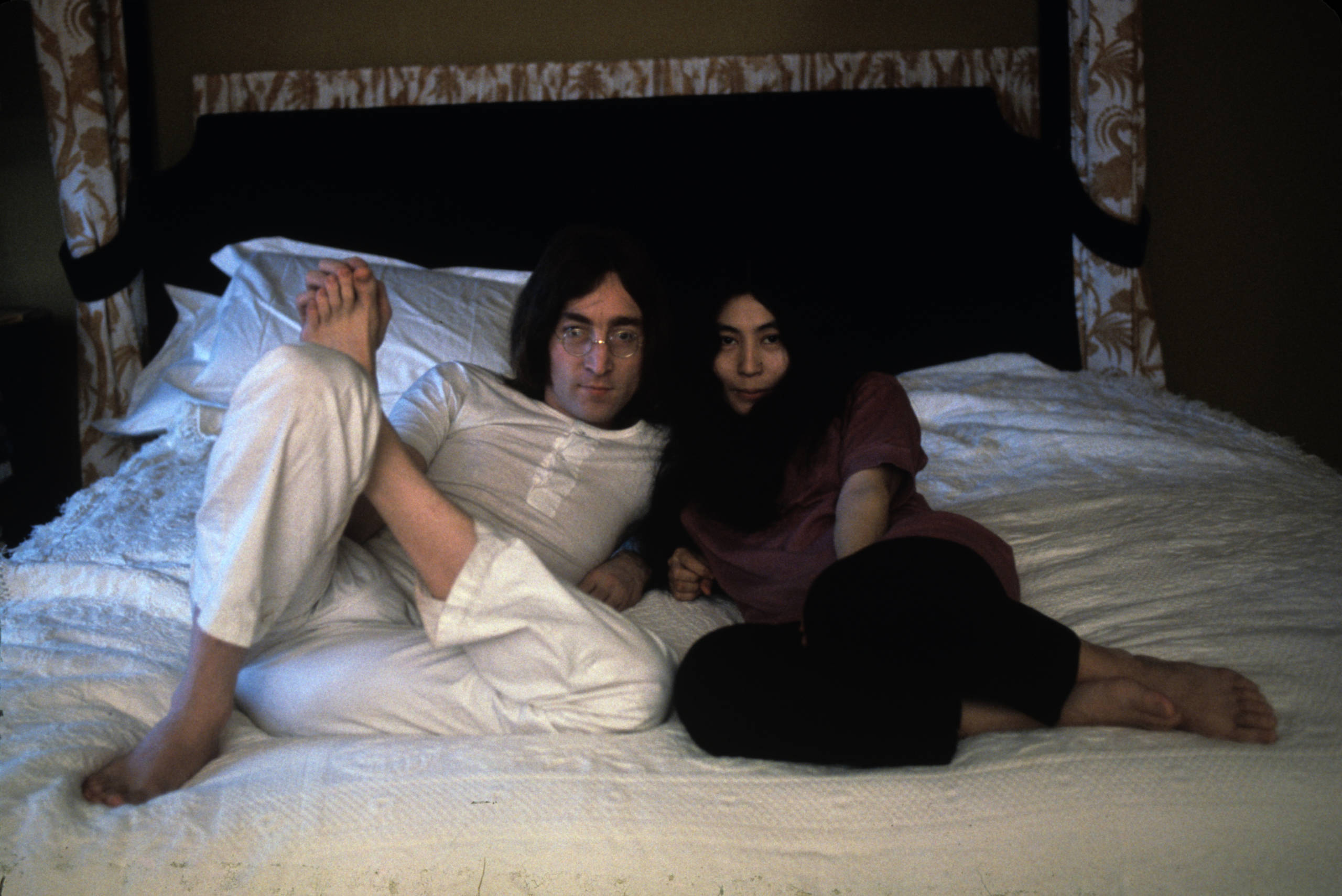 British musican and artist John Lennon (1940 - 1980) and Japanese-born artist and musician Yoko Ono pose together on a bed...