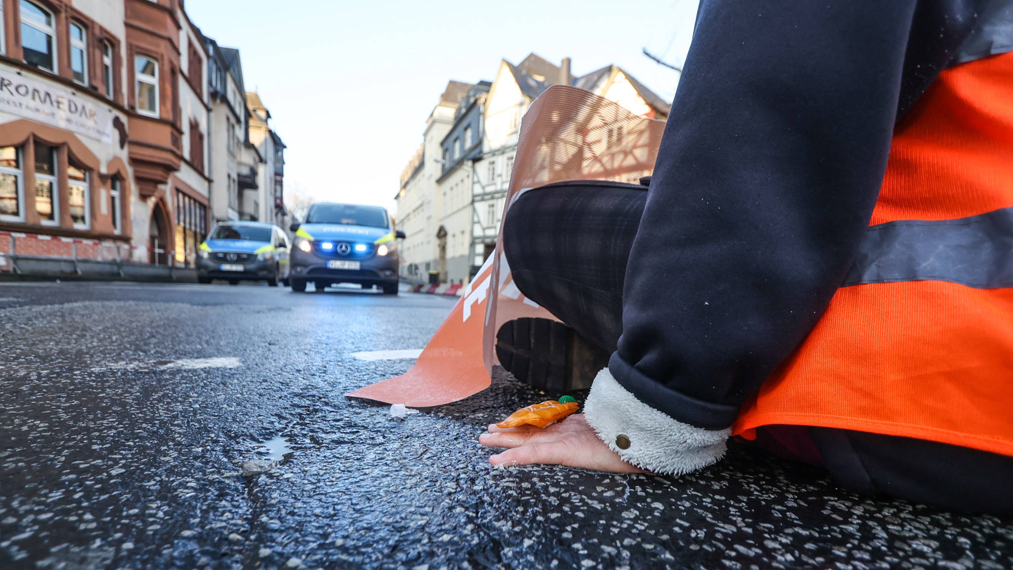 Die auf einer Straße in Marburg festgeklebte Hand einer Klamaaktivist*in der „Letzten Generation"