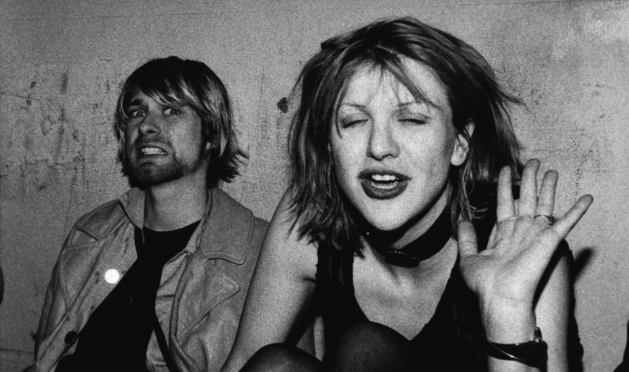 LOS ANGELES- DECEMBER 4: Kurt Cobain and Courtney Love pose for photograph, Kurt grimacing for the camera and Courtney wav...