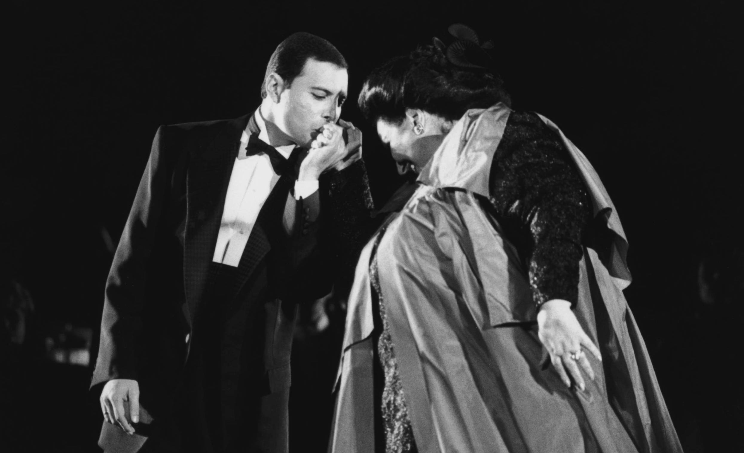 Singer Freddie Mercury kisses opera singer Montserrat Caballe on the hand as they perform 'Barcelona' at a music festival ...