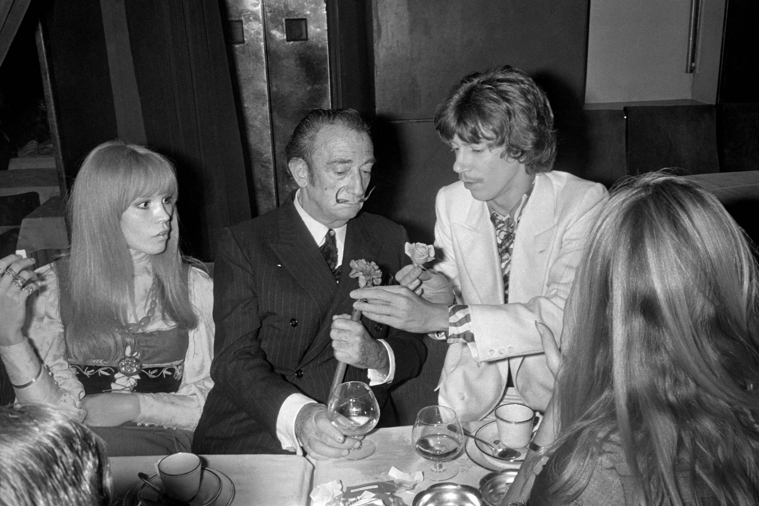 French singer Antoine (R) offers a rose to Spanish artist Salvador Dali (C), giving him the carnation of his buttonwhole, ...
