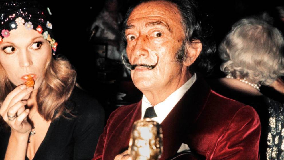 Spanish painter Salvador Dali and French actress and singer Amanda Lear have dinner in a restaurant in Paris in December 1971