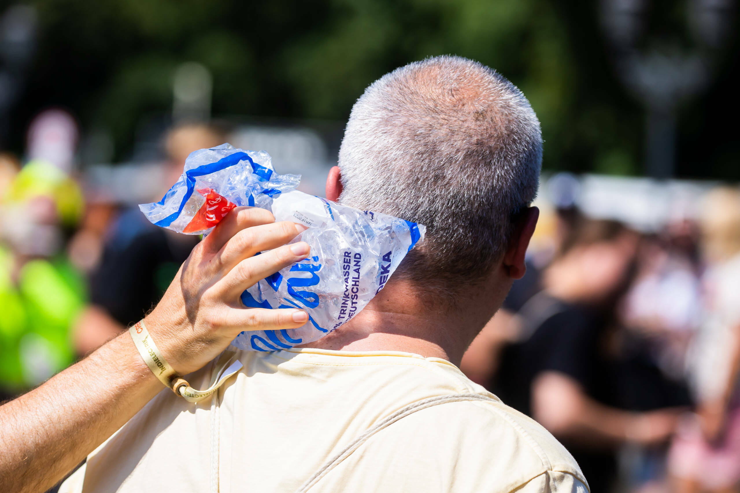 Eine Person hält einer anderen bei der Technoparade «Rave the Planet» auf der Straße des 17. Juni einen Eisbeutel in d...
