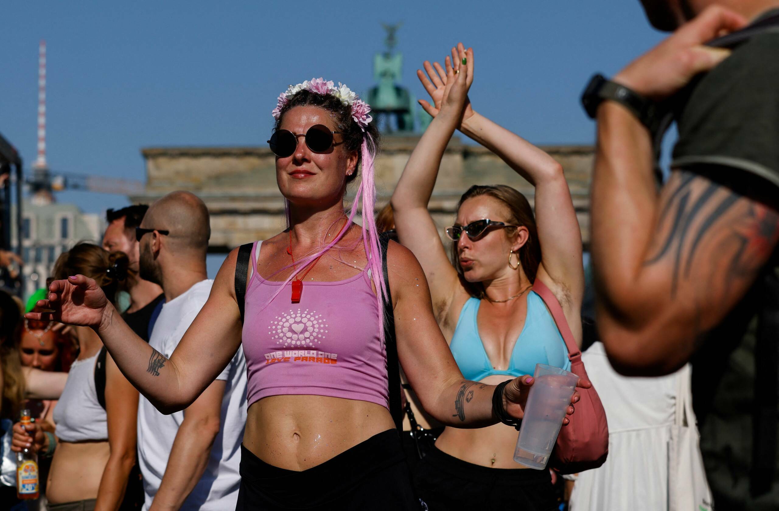 People dance as they pass the capital's landmark Brandenburg Gate during the "Rave the Planet" techno music parade on July...