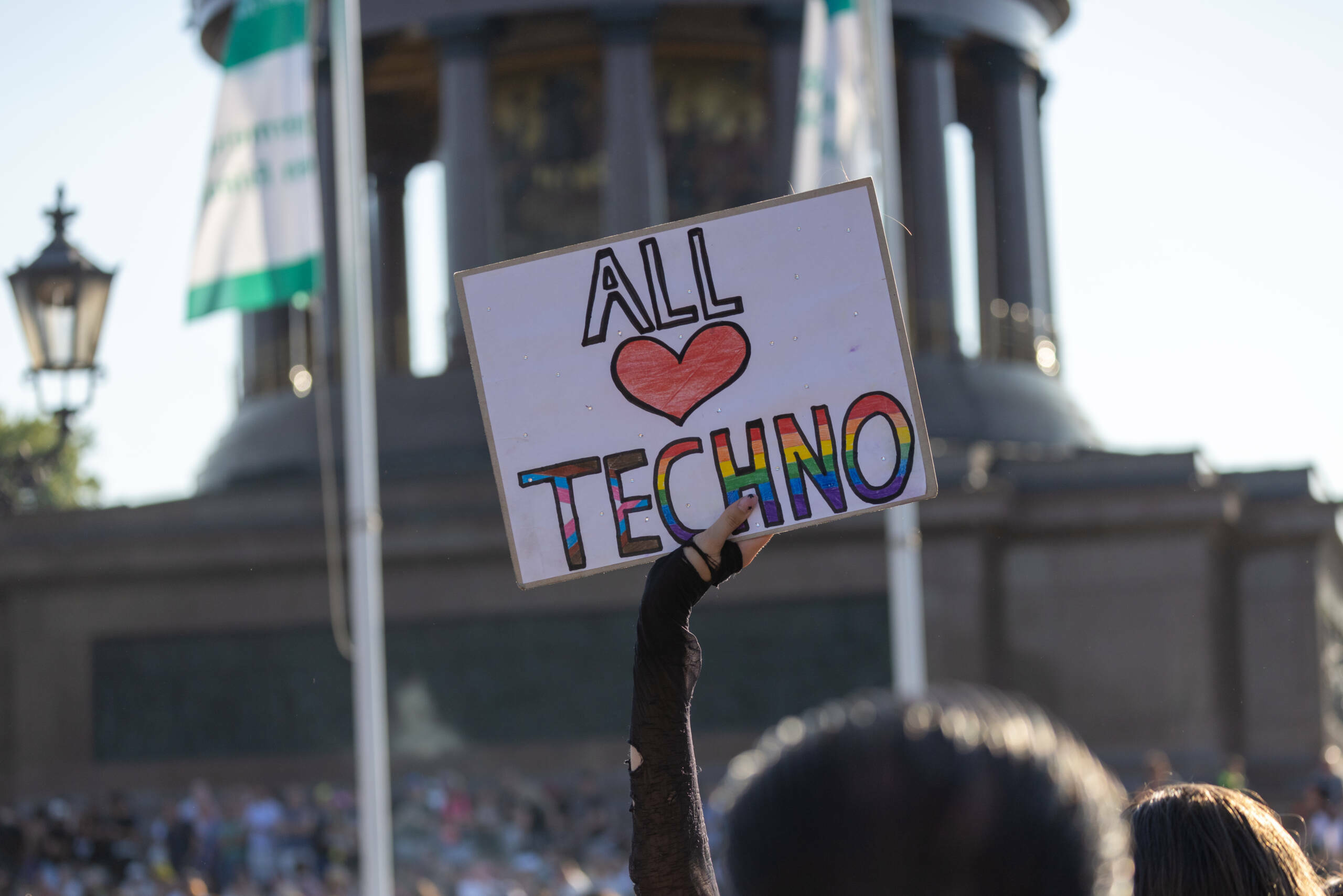 BERLIN, GERMANY - JULY 8: A techno music enthusiast holds a poster that reads All love Techno and dances during the Rave t...