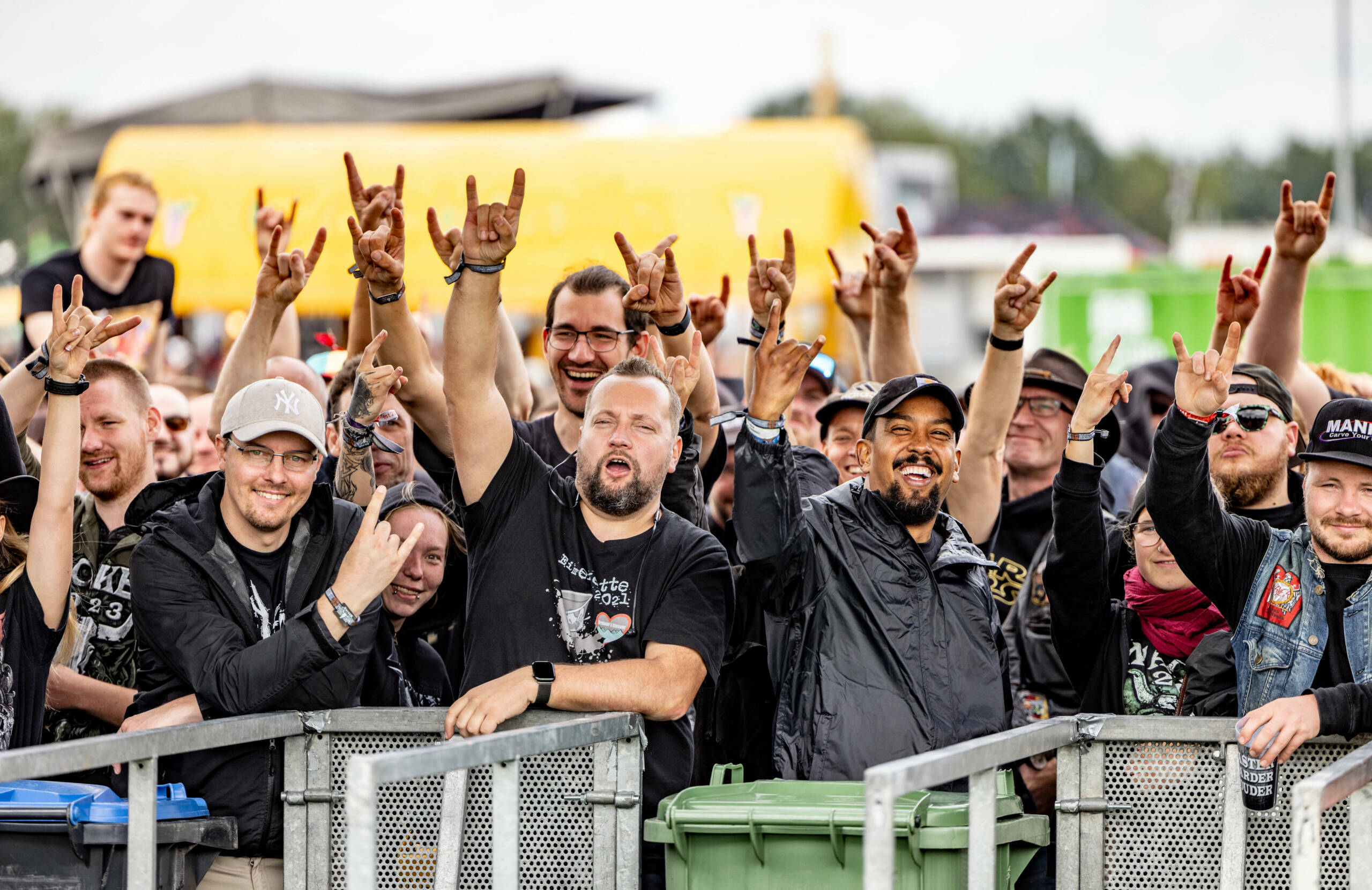 Visitors of the Wacken Open Air music festival show the sign of the horns hand gesture as they wait for entrance to the fe...
