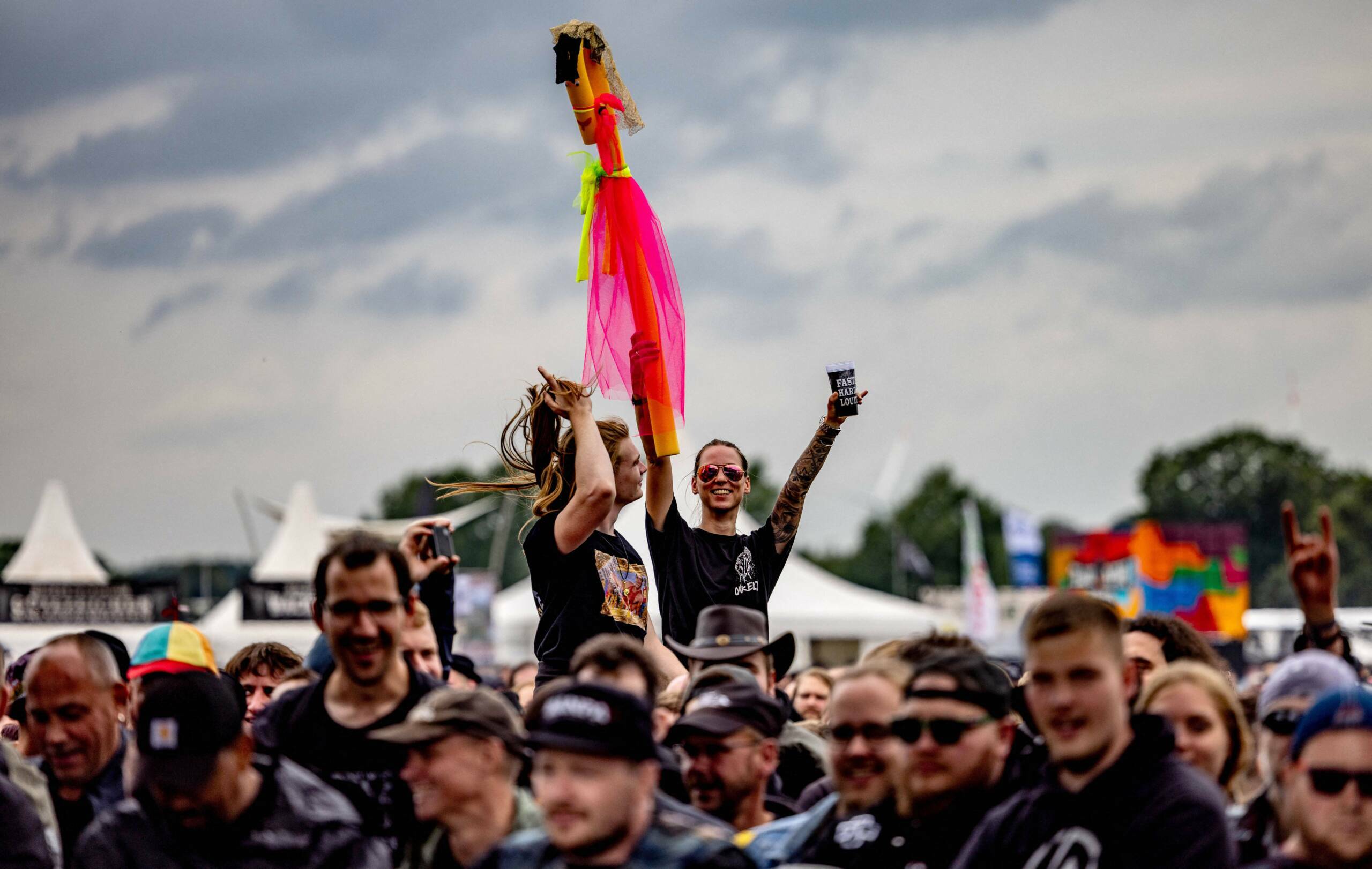 Festival-goers cheer as they attend the Wacken Open Air music festival on August 2, 2023 in Wacken, northern Germany. The ...