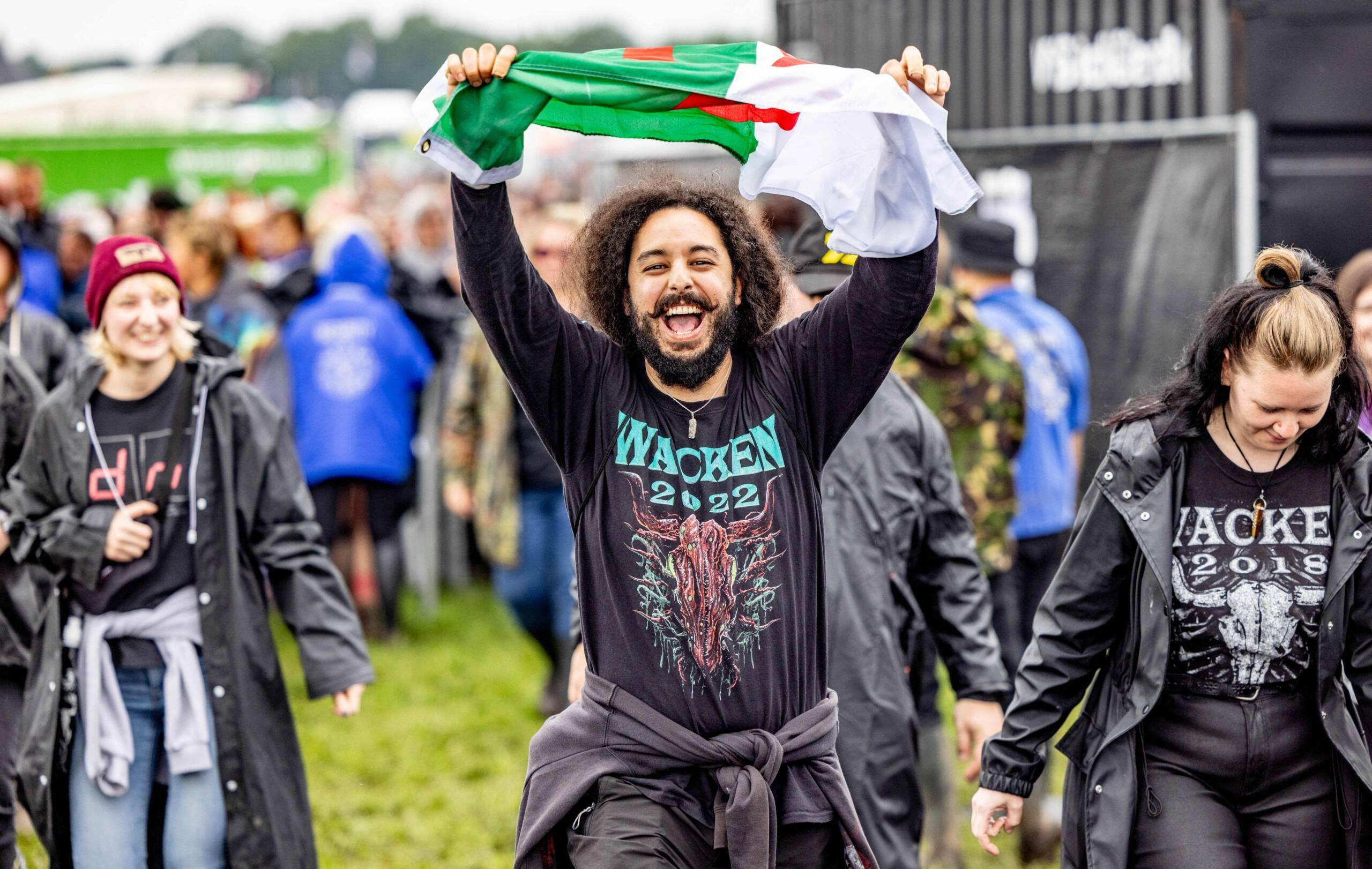 A festival-goer cheers as he enters the grounds of the Wacken Open Air music festival on August 2, 2023 in Wacken, norther...