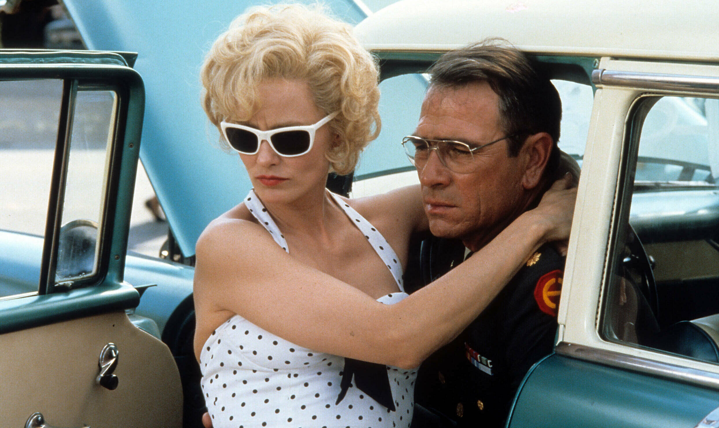 Jessica Lange with her arms around Tommy Lee Jones neck while she looks away from him in a scene from the film 'Blue Sky',...