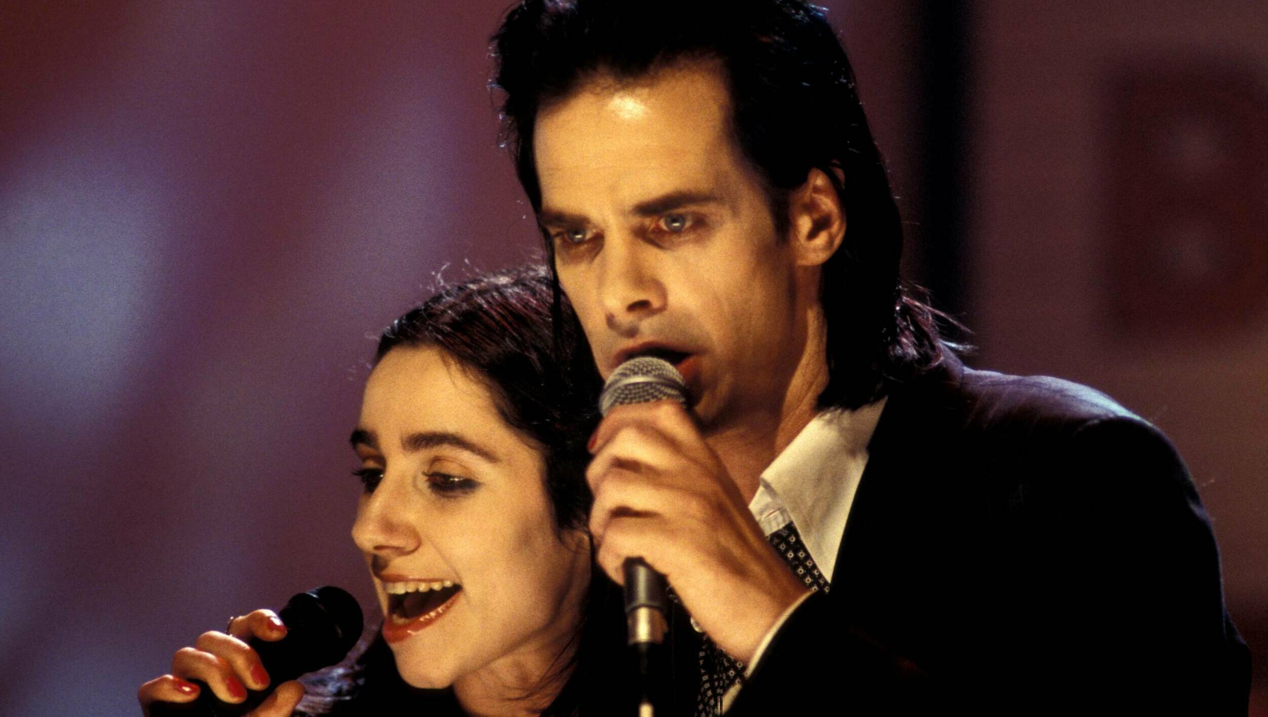 Musicians PJ Harvey (left) and Nick Cave (right) perform together on Channel 4 music TV series 'The White Room', London, 1...