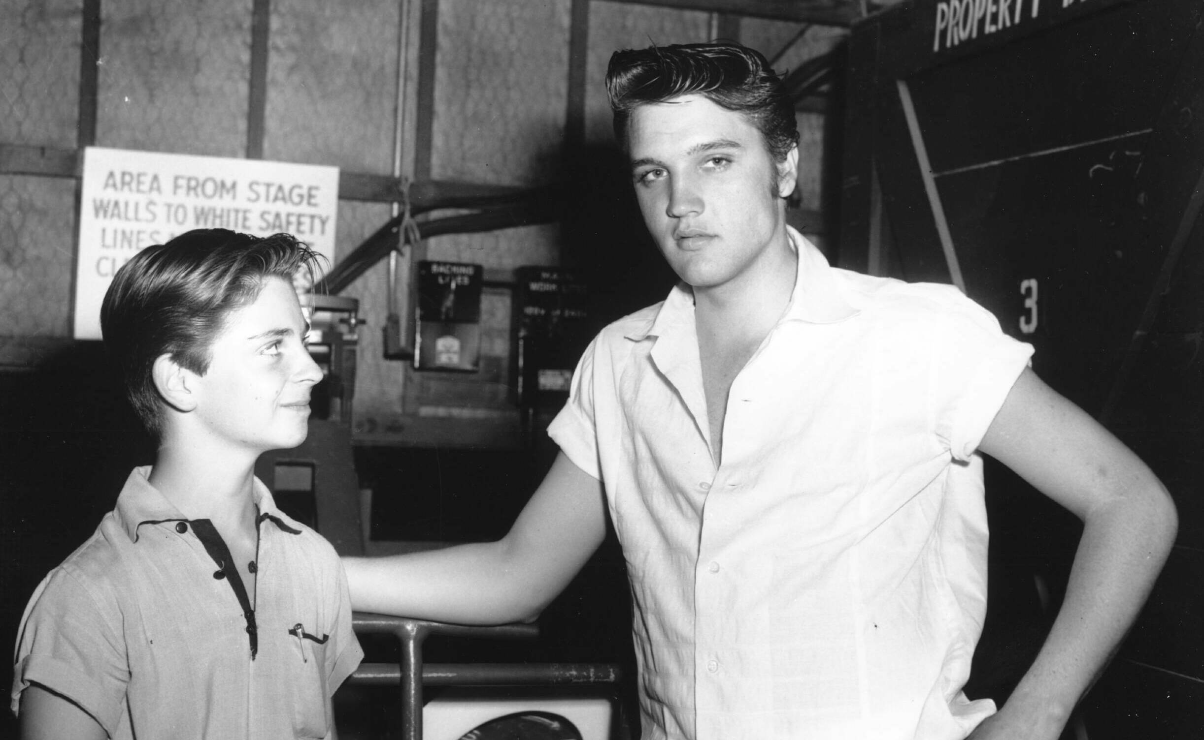 HOLLYWOOD - 1956: Rock and roll singer Elvis Presley behind the scenes at a movie set talking to a fans in 1956. (Photo by...