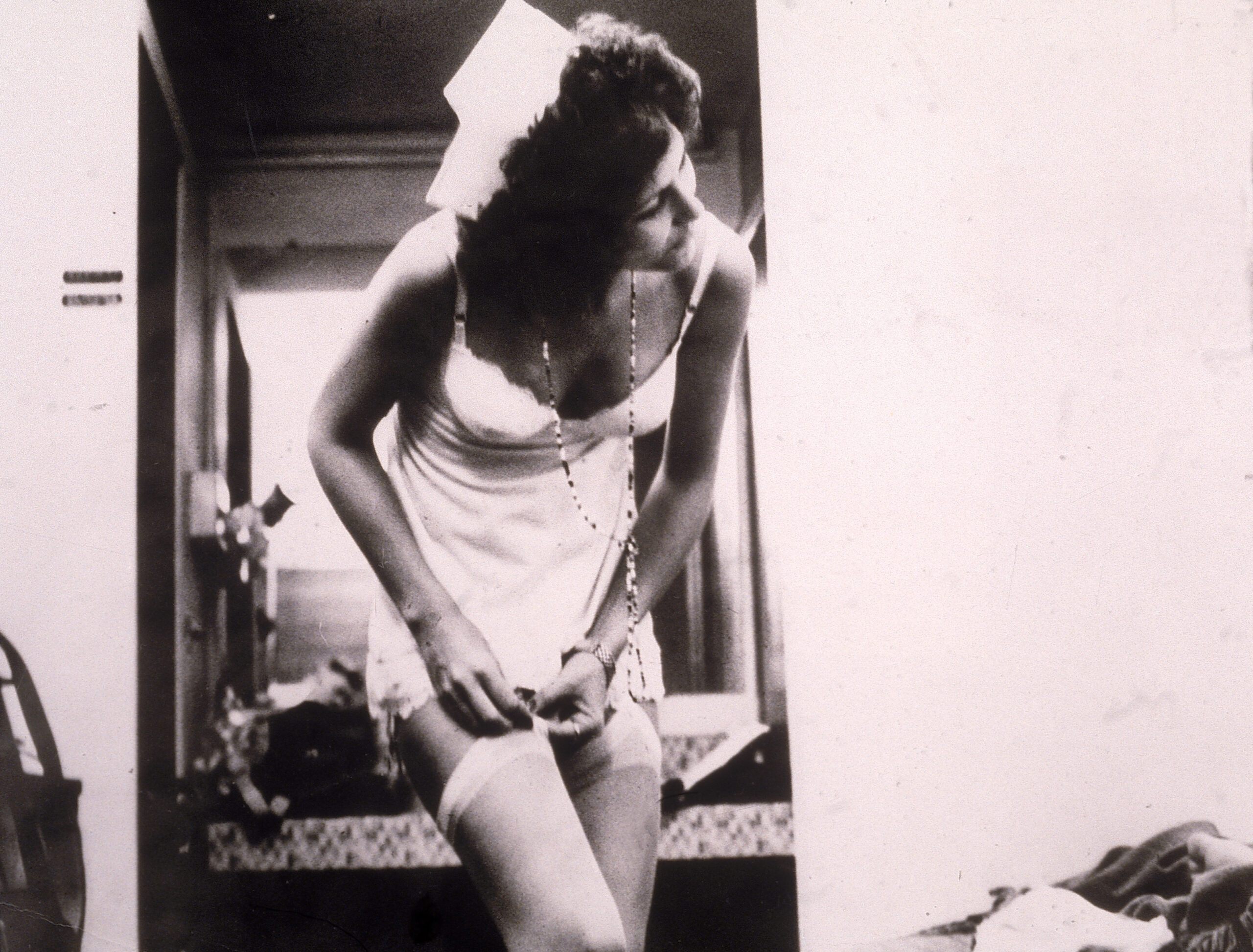 American actor Linda Lovelace (1949 - 2002) removes her stocking, wearing a slip and a nurse's hat in a still from the fil...