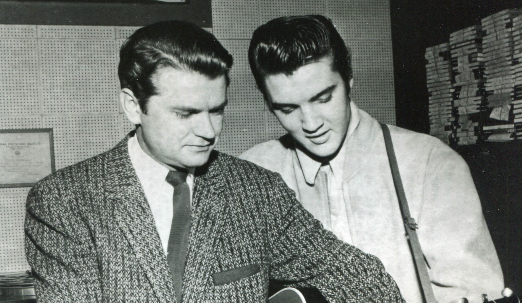 Der Besitzer von Sun Records, Sam Phillips, und Elvis Presley greifen beide einen Akkord auf derselben Gitarre (1956)