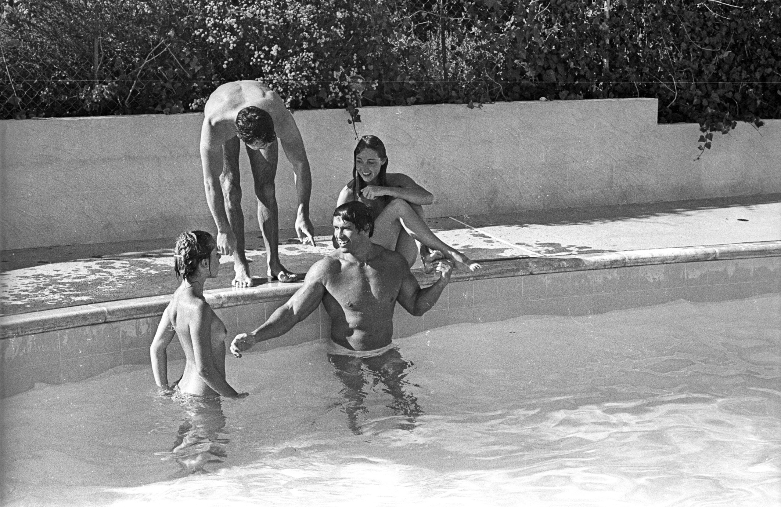 Actor and bodybuilder Arnold Schwarzenegger and actress Nastassja Kinski (in pool) with actor Johnny Crawford and Debra Ta...