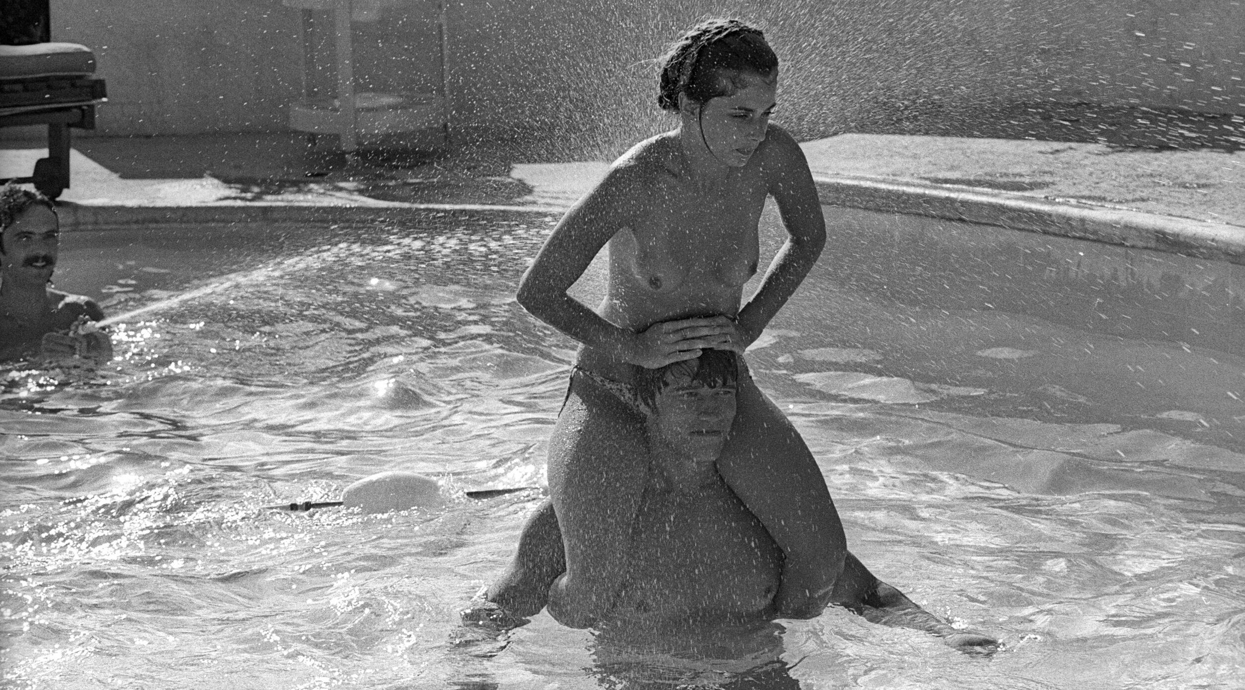 LOS ANGELES - 1976: Actor and body builder Arnold Schwarzenegger plays with a topless Nastassja Kinski on his shoulders in...