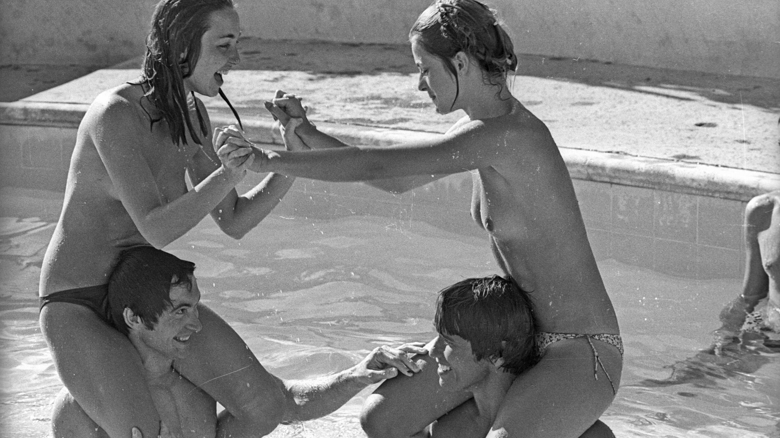 Actor Johnny Crawford and Debra Tate (left) chicken fighting with Arnold Schwarzenegger and Nastassja Kinski in a swimming...