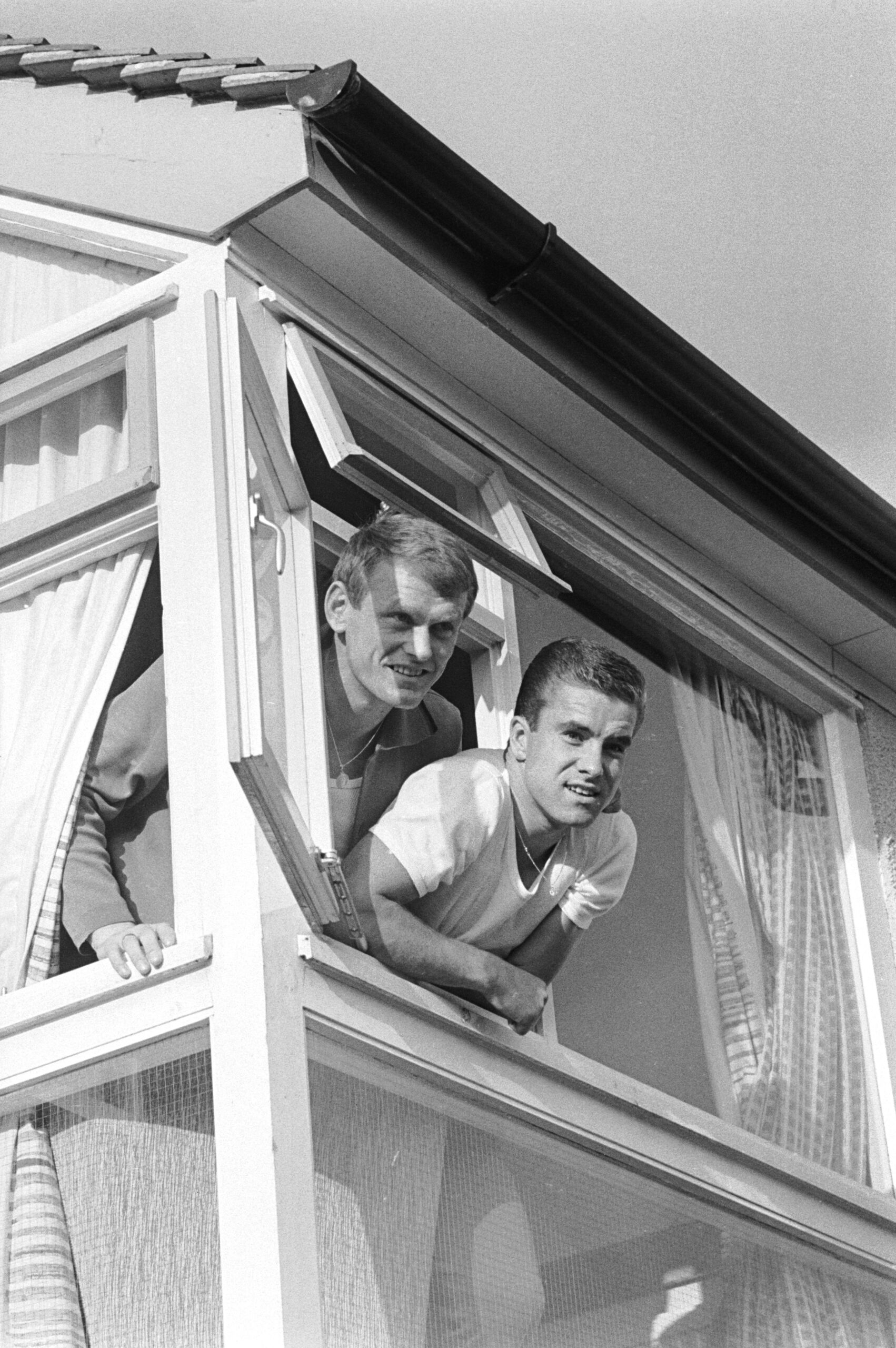 West German players Sepp Maier and Bernd Patzke leaning out of their hotel room at Peverill of the Peak where their nation...