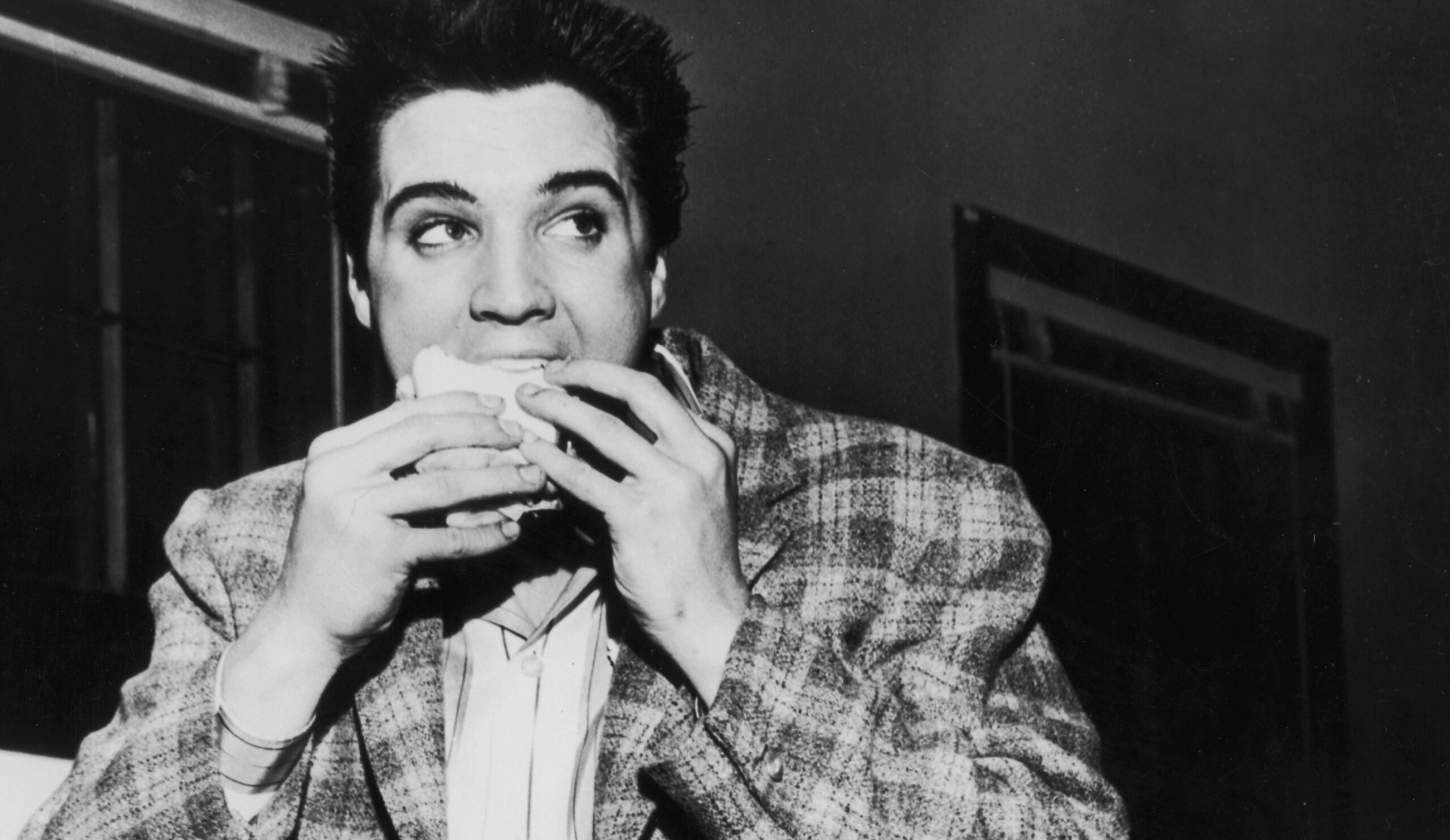Elvis Presley isst ein Sandwich, vielleicht mit Erdnussbutter