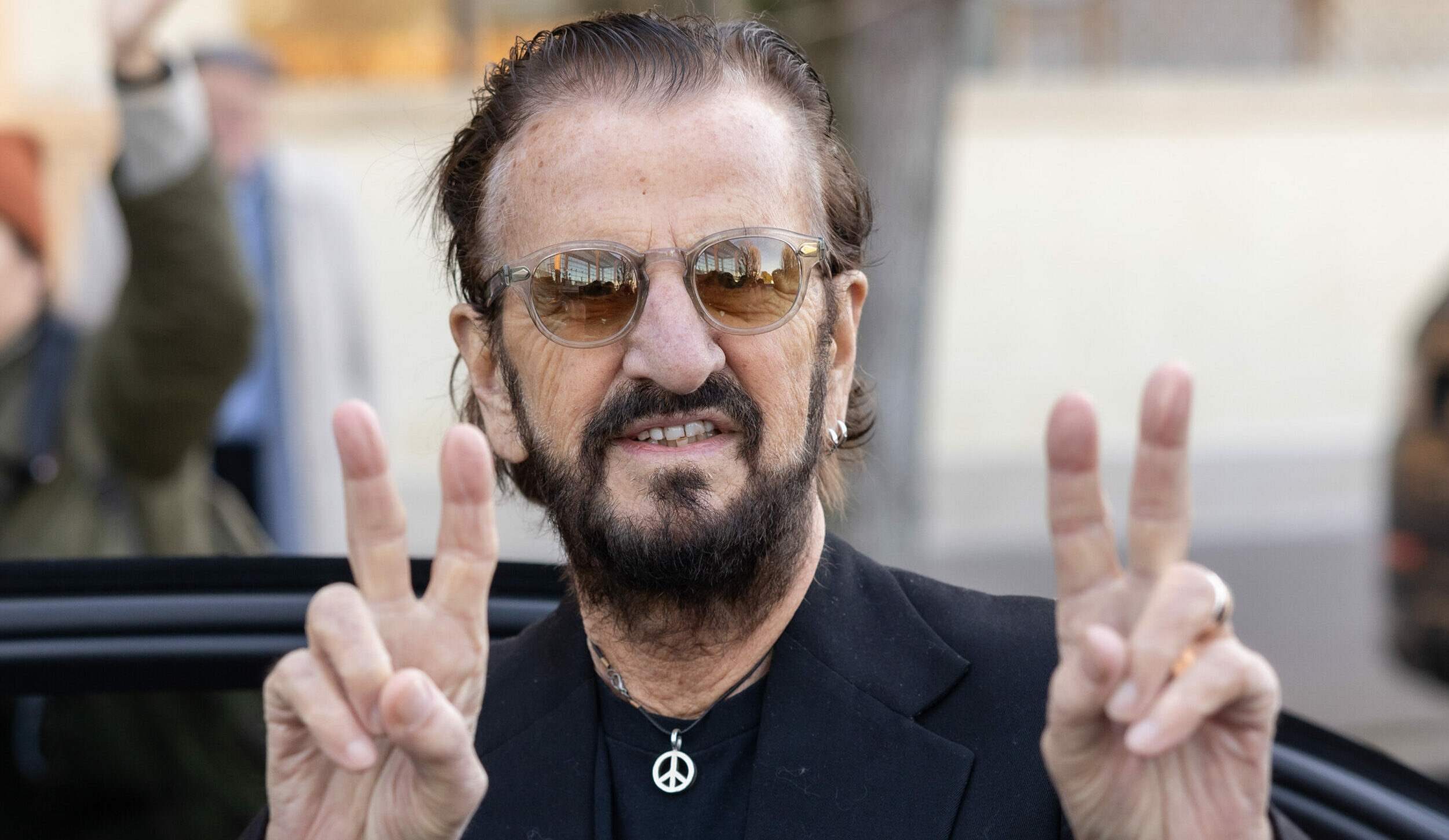 Ringo Starr zeigt sein berühmtes Peace-Zeichen