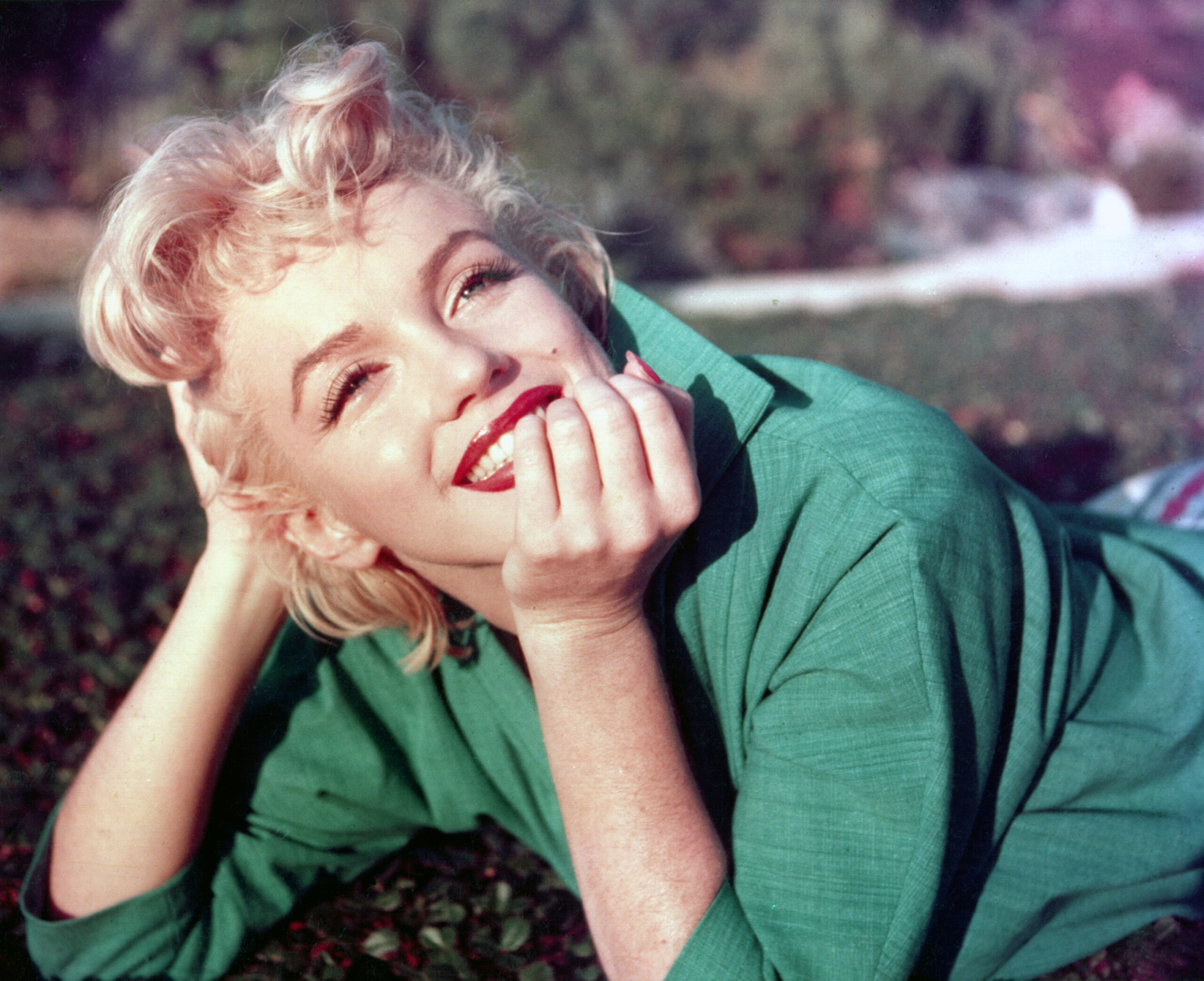 PALM SPRINGS, CA - 1954: Actress Marilyn Monroe poses for a portrait laying on the grass in 1954 in Palm Springs, Californ...
