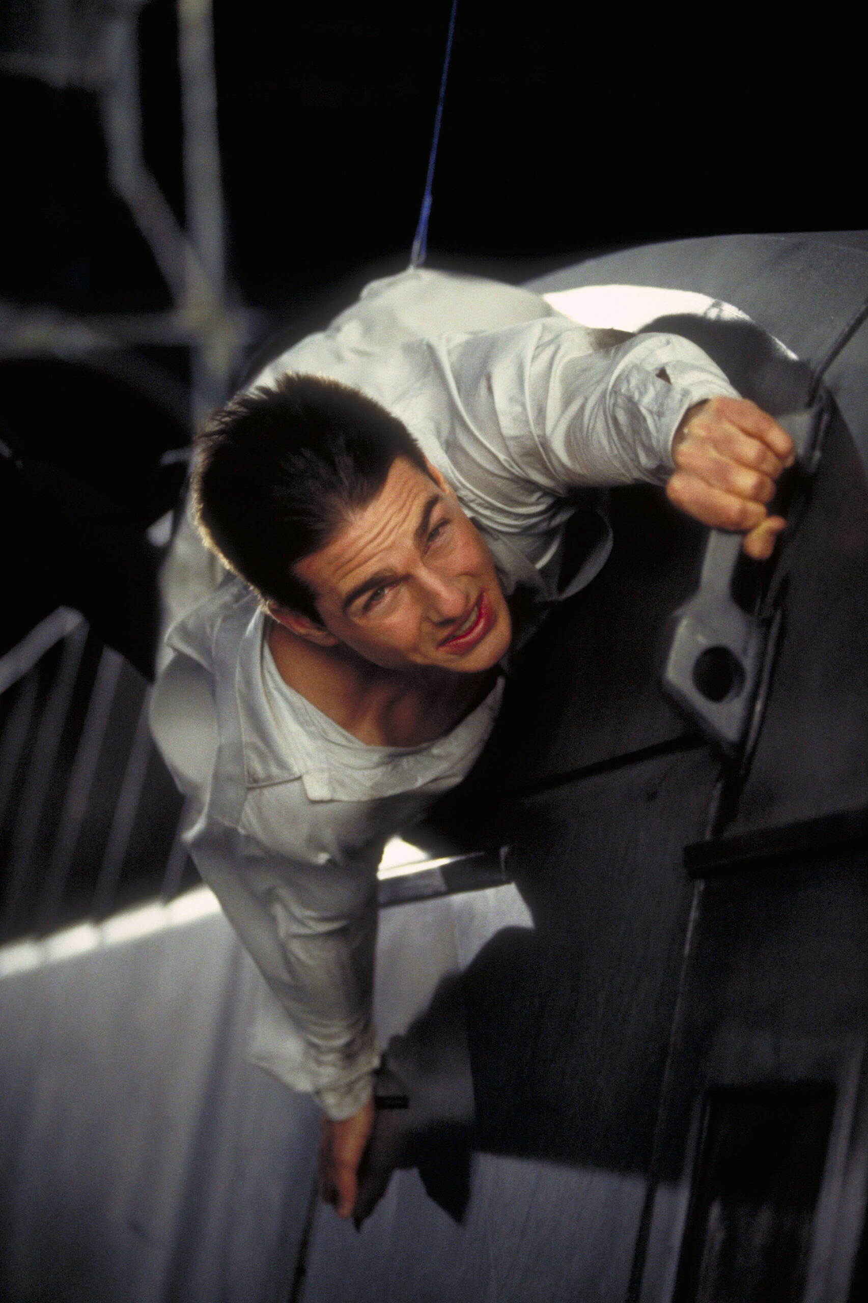 American actor Tom Cruise as Ethan Hunt, filming a scene for the movie 'Mission: Impossible' at Pinewood Studios, 1995.  I...