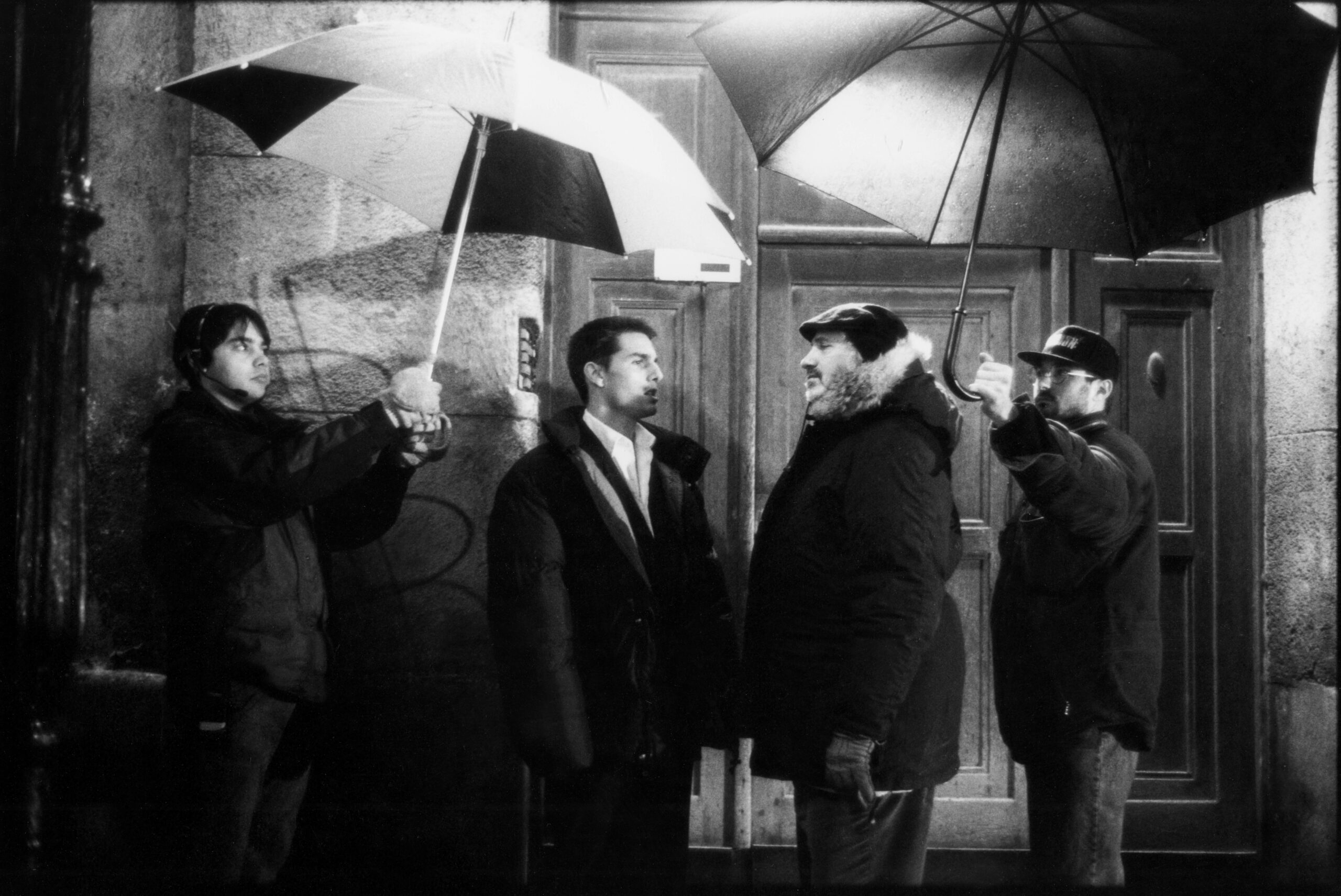 American actor Tom Cruise (in costume as Ethan Hunt) (second left) and film director Brian De Palma talk on the set of the...