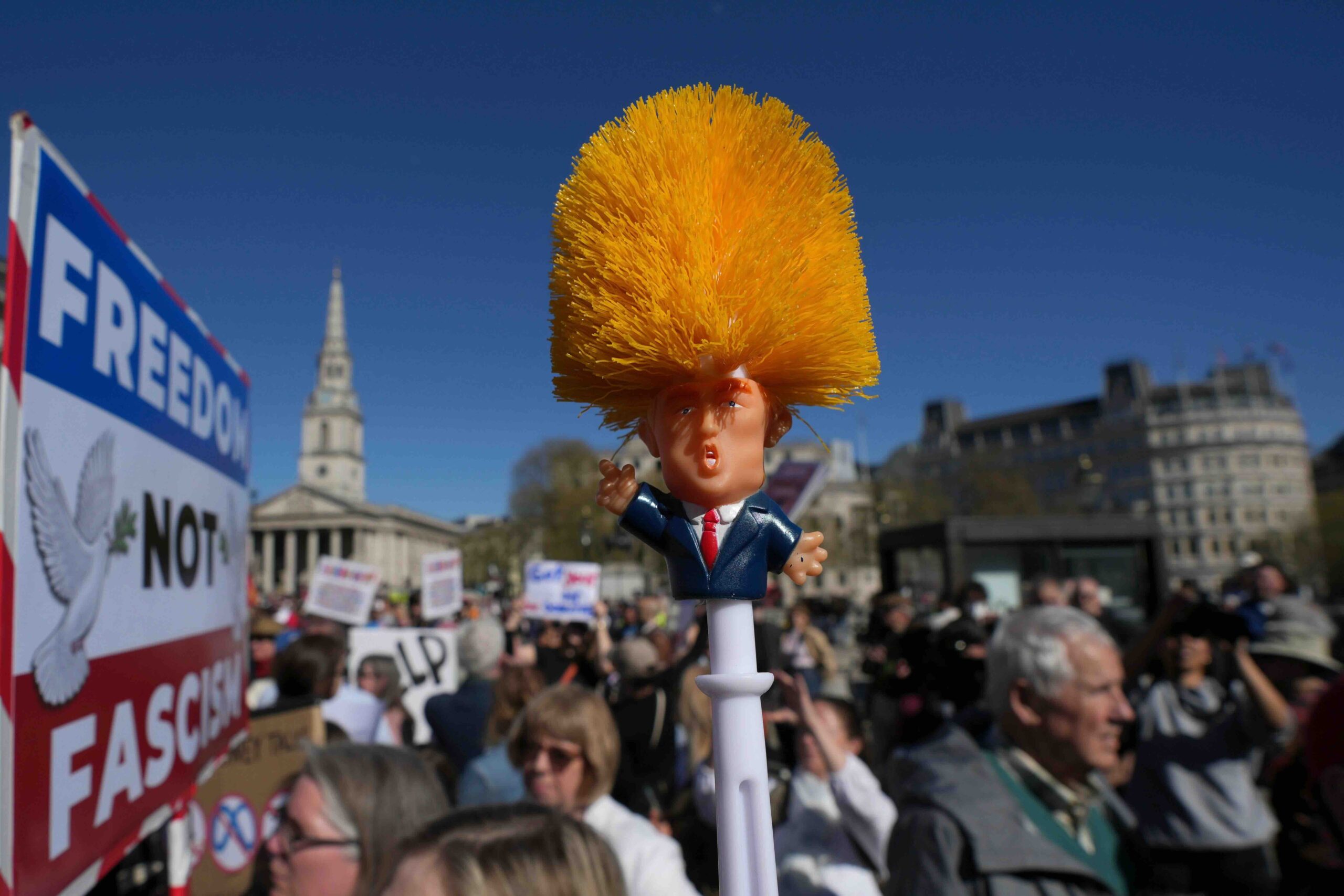 Der britische Demonstrant Hugo Brooks (r) hält eine Klobürste mit einer Figur des US-Präsidenten Donald Trump in der Ha...