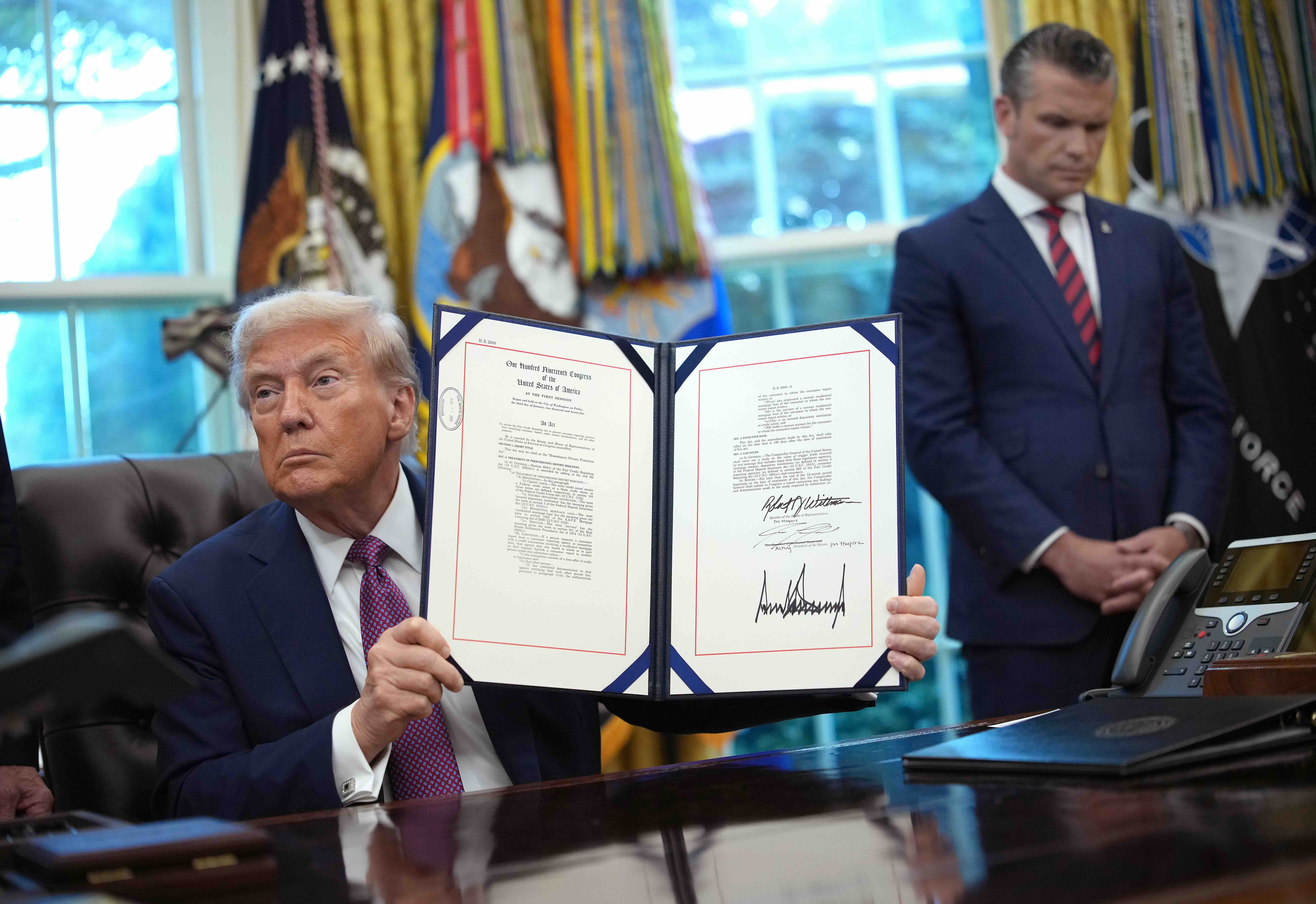 WASHINGTON, DC - SEPTEMBER 05: U.S. President Donald Trump holds up the Homebuyers Privacy Protection Act after signing it...