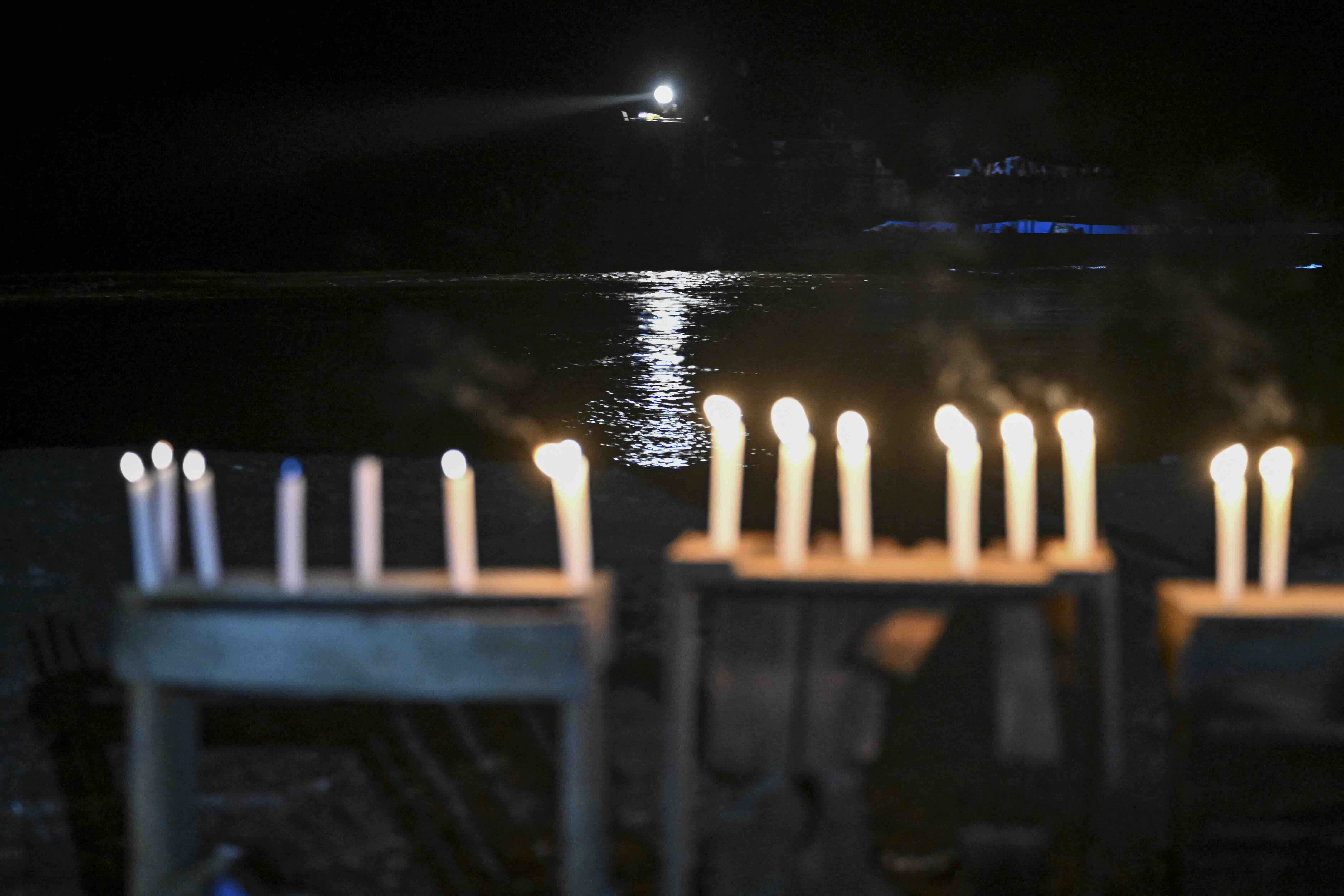 This view shows candles on the riverbank of the Ucayali during a vigil following a boat accident at the port of Iparia, in...