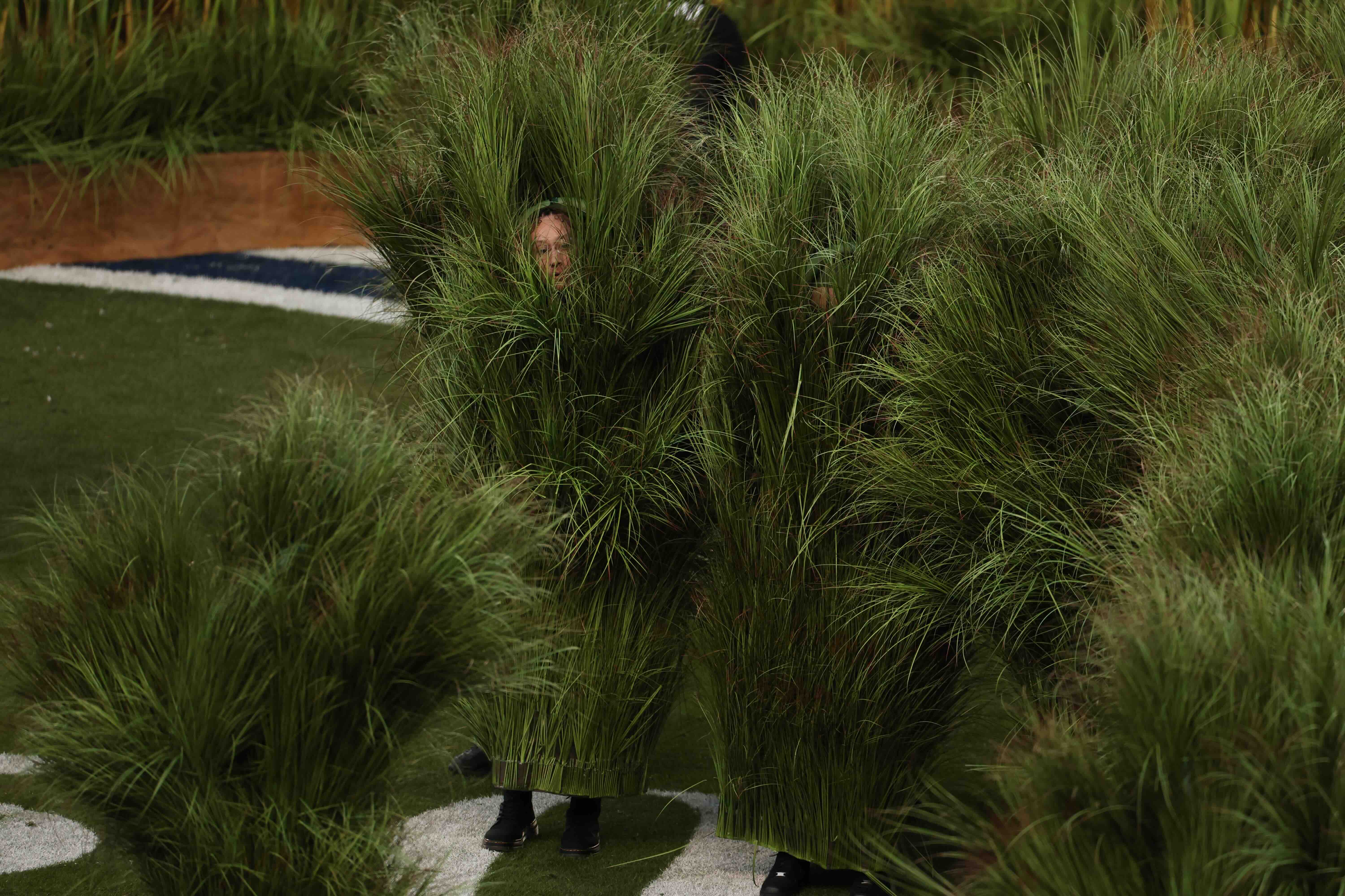 Performers dressed as Sugarcane grass step on stage for Puerto Rican singer Bad Bunny performance during Super Bowl LX Pat...